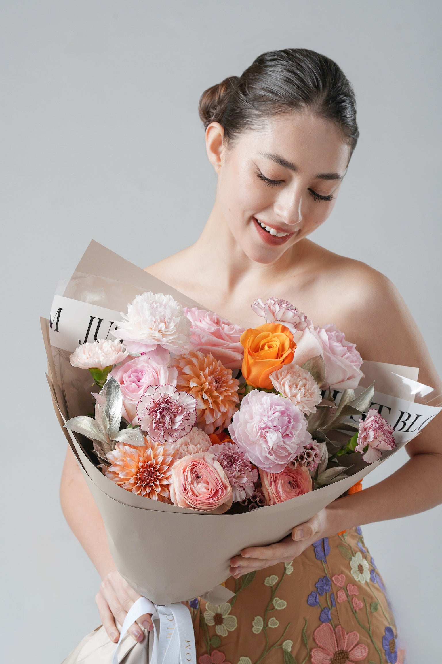 A lush peach and orange garden-style bouquet with garden roses, dahlias, and soft blush carnations.