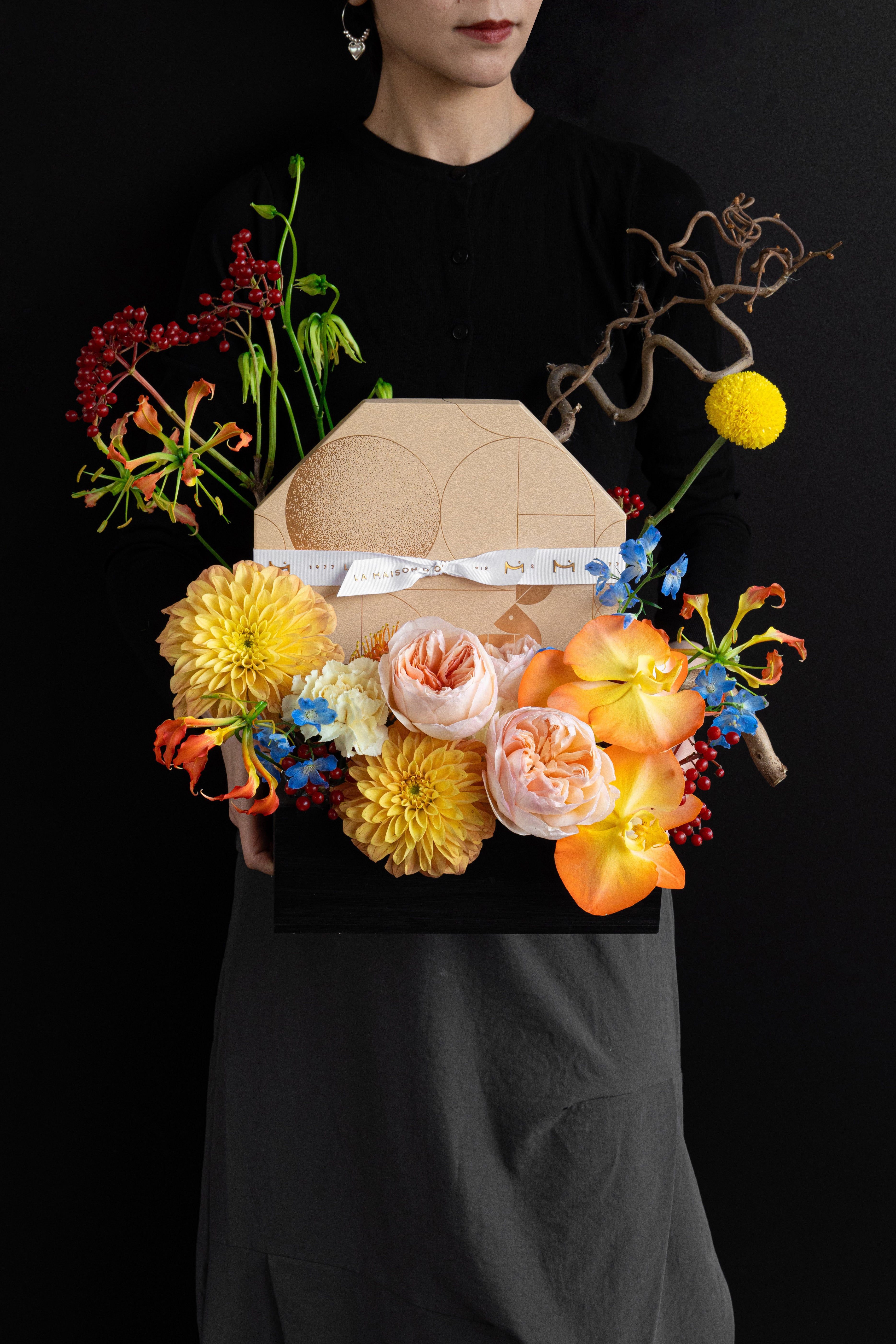 Model holding Just Bloom Autumn Reflection flower box with golden yellow and coral florals and chocolate gift box — Just Bloom Hong Kong