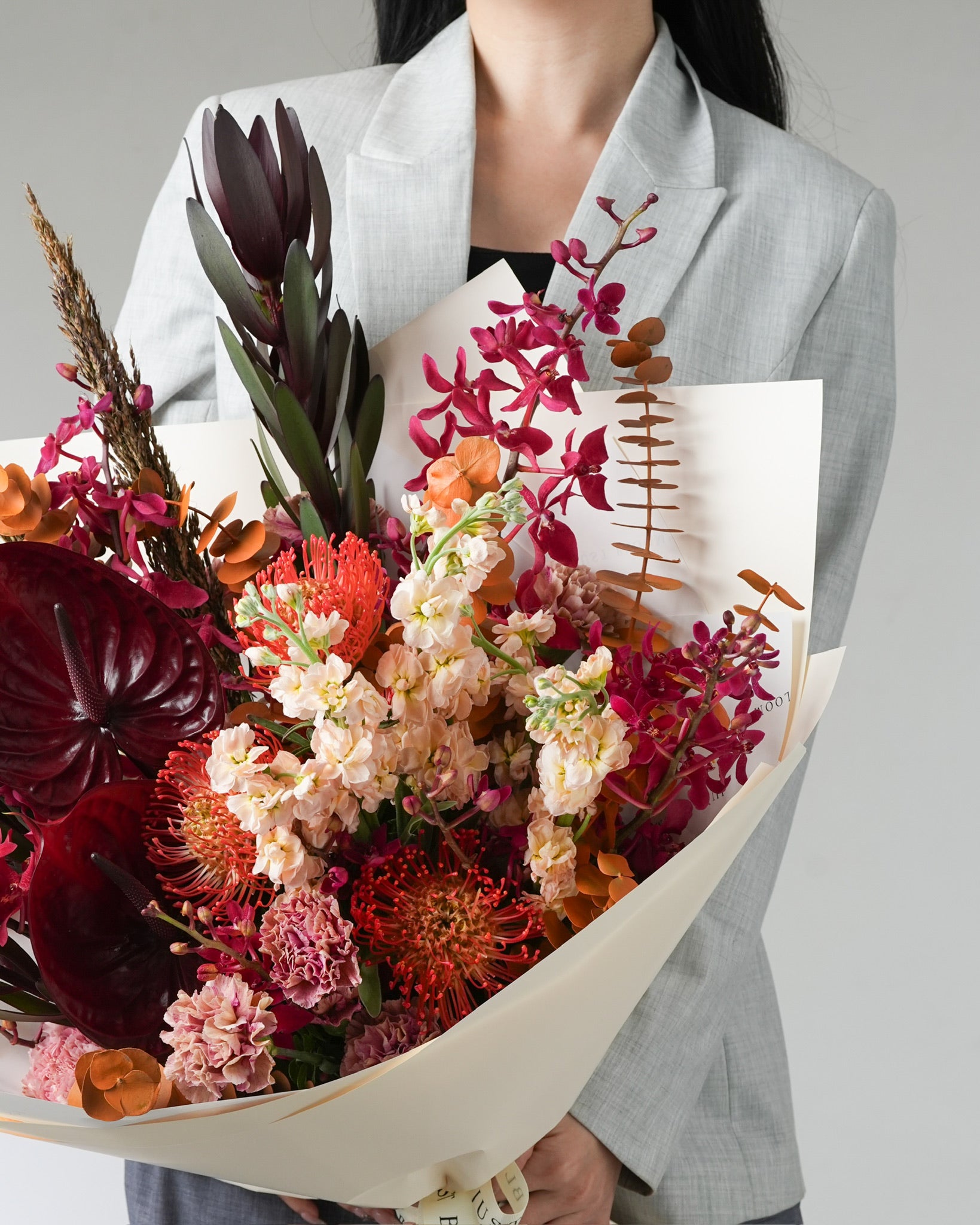 Close-up of Inferno bouquet showing anthuriums, pincushion proteas and plush blooms with refined textures by Just Bloom Hong Kong
