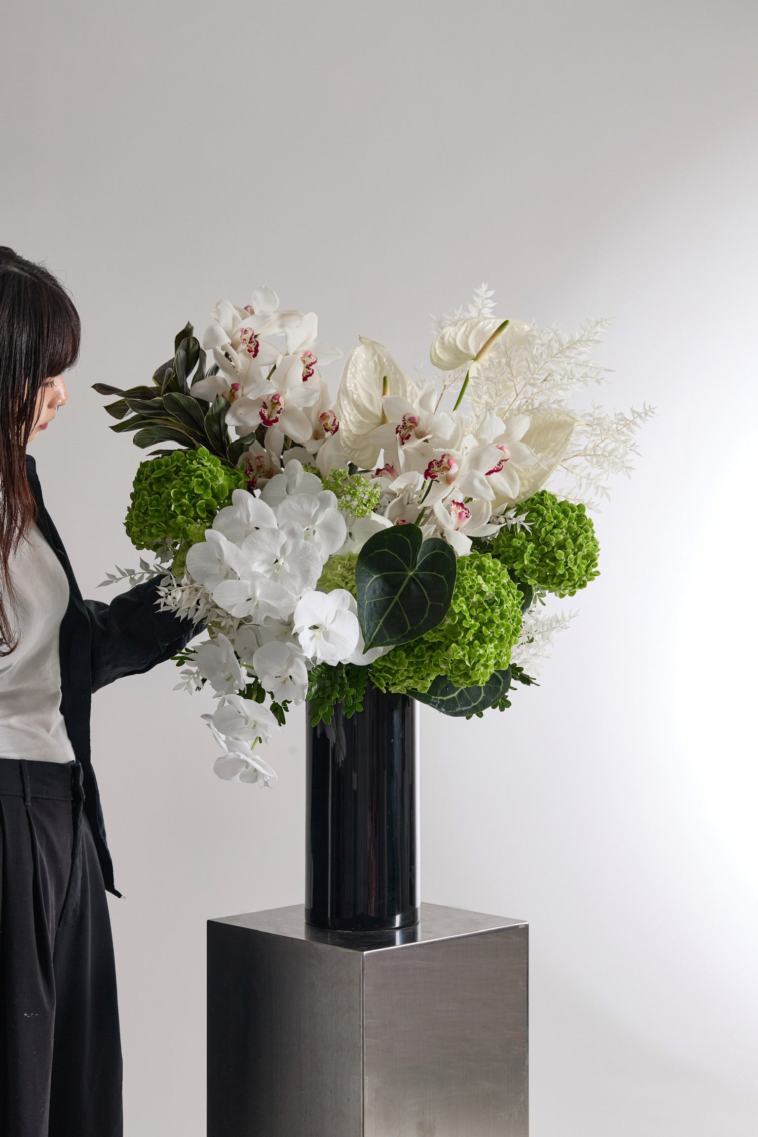 Ivory Verdure modern floral arrangement in dark ceramic vase with white orchids and green hydrangeas