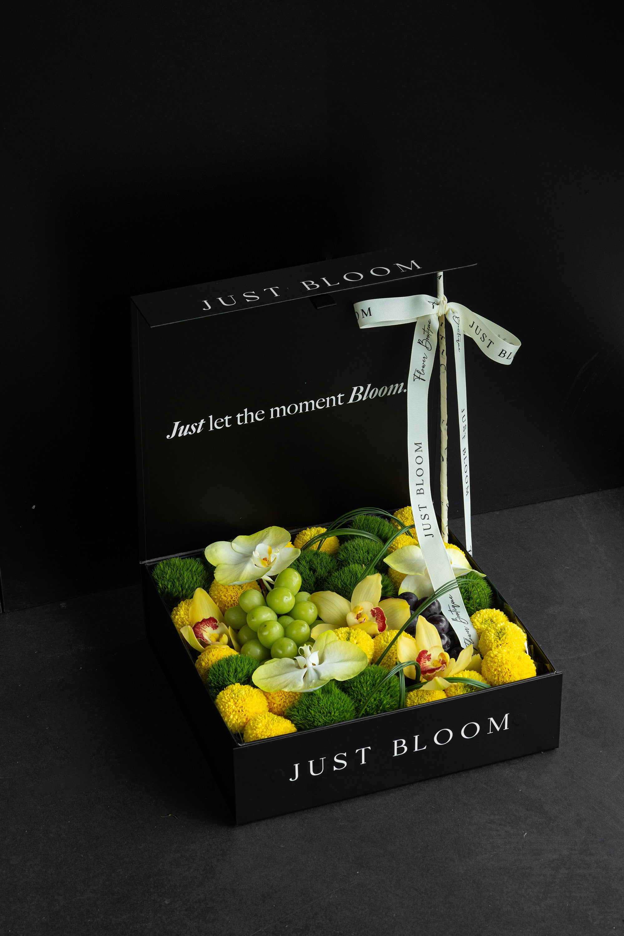 Just Bloom Jade Moon flower box with yellow and green florals and grapes against a black background — Just Bloom Hong Kong