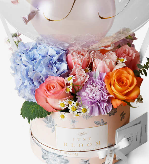 An enchanting image of a Flower Box filled with premium Ecuadorian roses, Dutch hydrangeas, eustomas, and tulips, creating a lively and vibrant atmosphere.