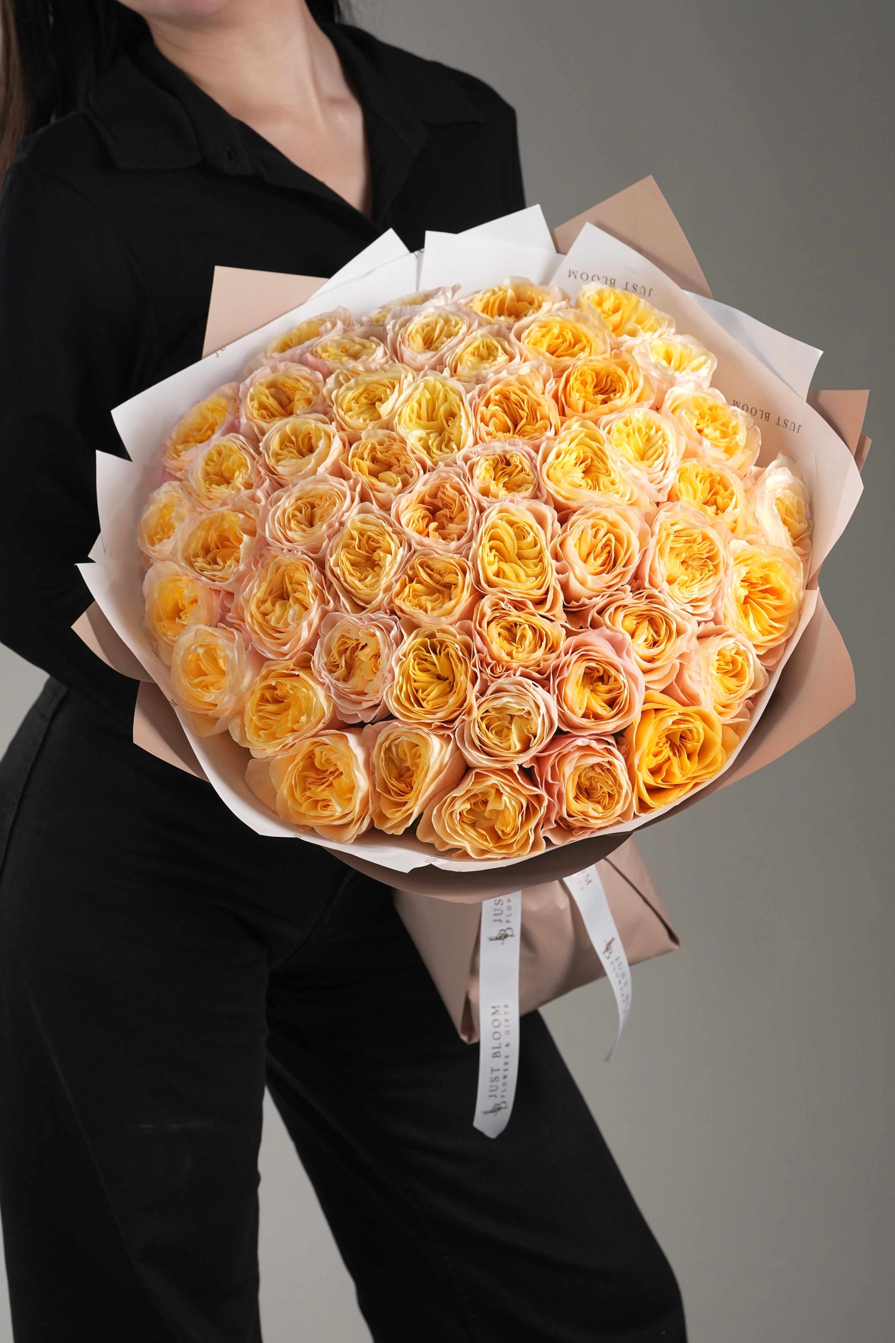 Premium champagne garden rose bouquet held by model in black outfit – Genesis by Just Bloom HK
