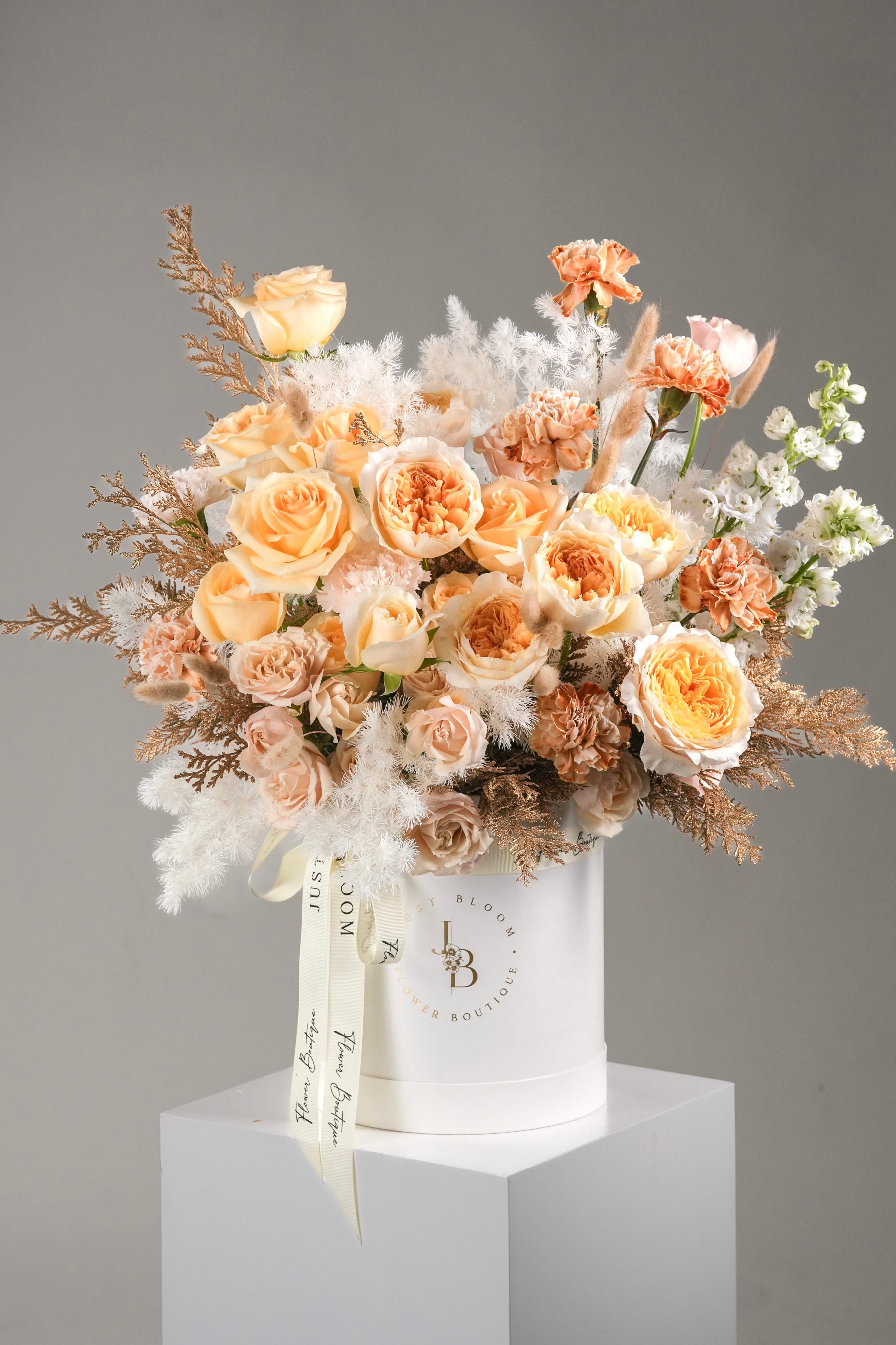 Kamiyah flower box with champagne roses, nude carnations, golden foliage and soft white fillers