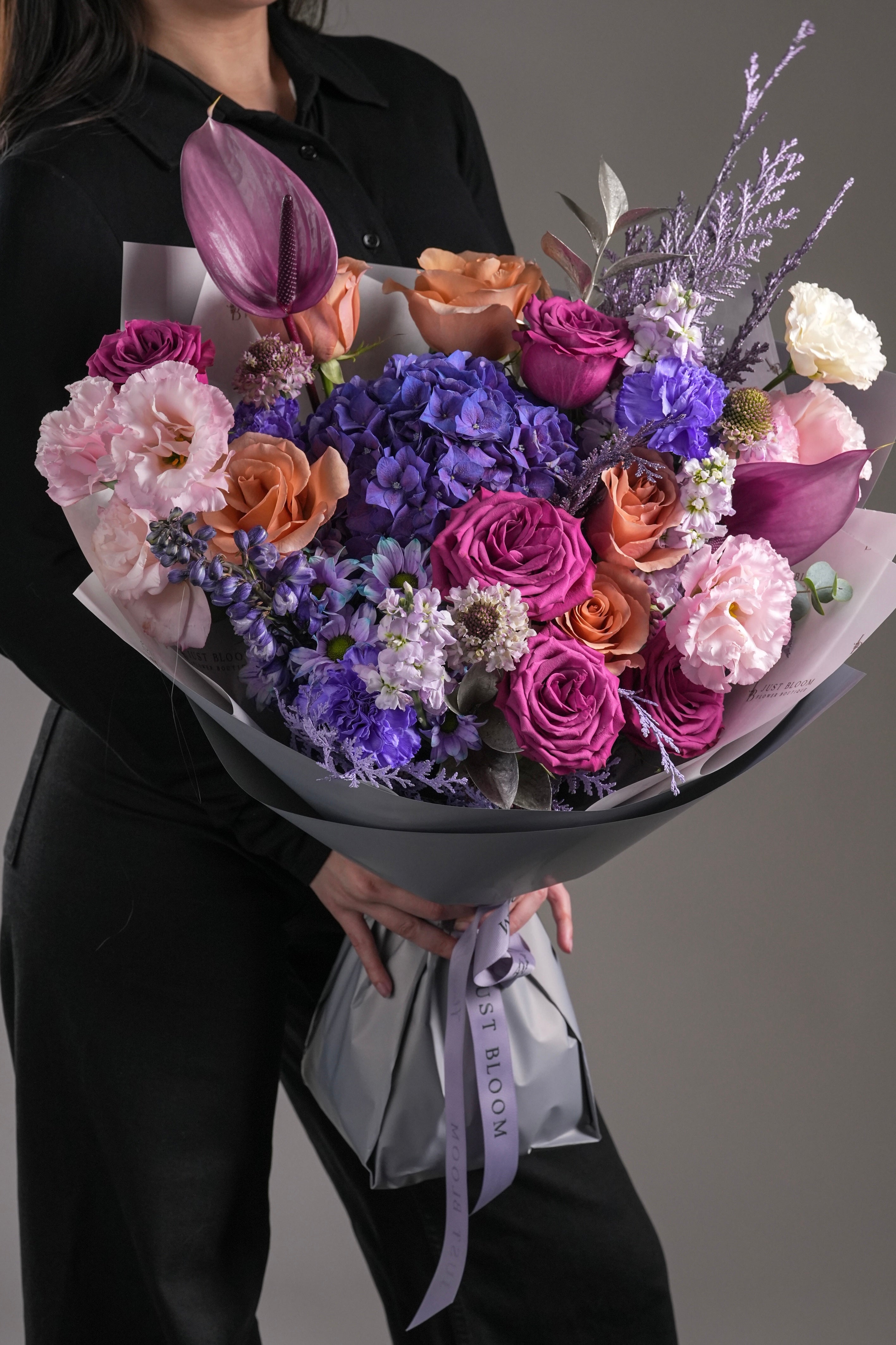 Close-up view of Kaylee bouquet showing purple hydrangeas and mixed colored roses arrangement