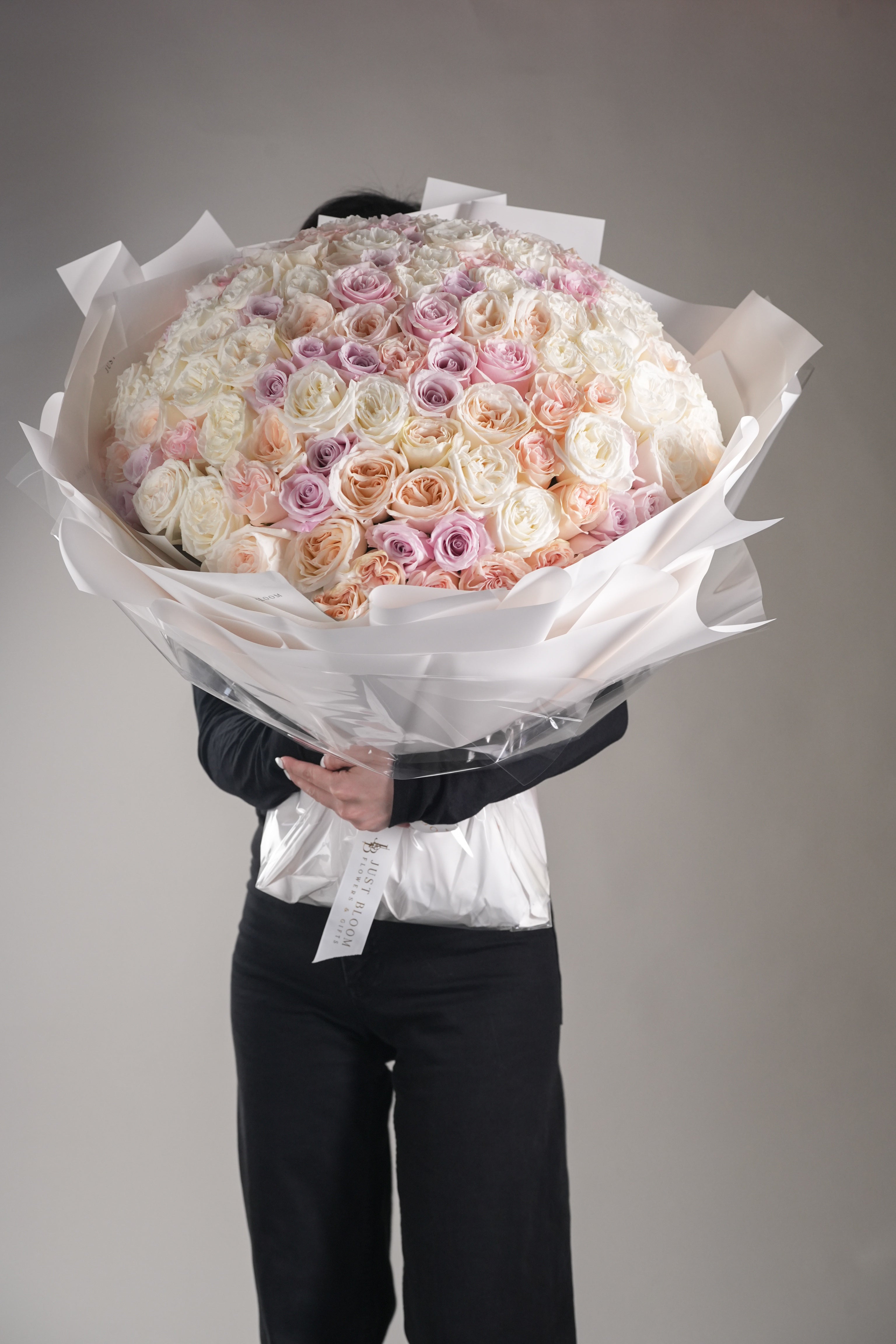 Kelly large rose bouquet showing full scale and elegant white wrapping with mixed rose colors
