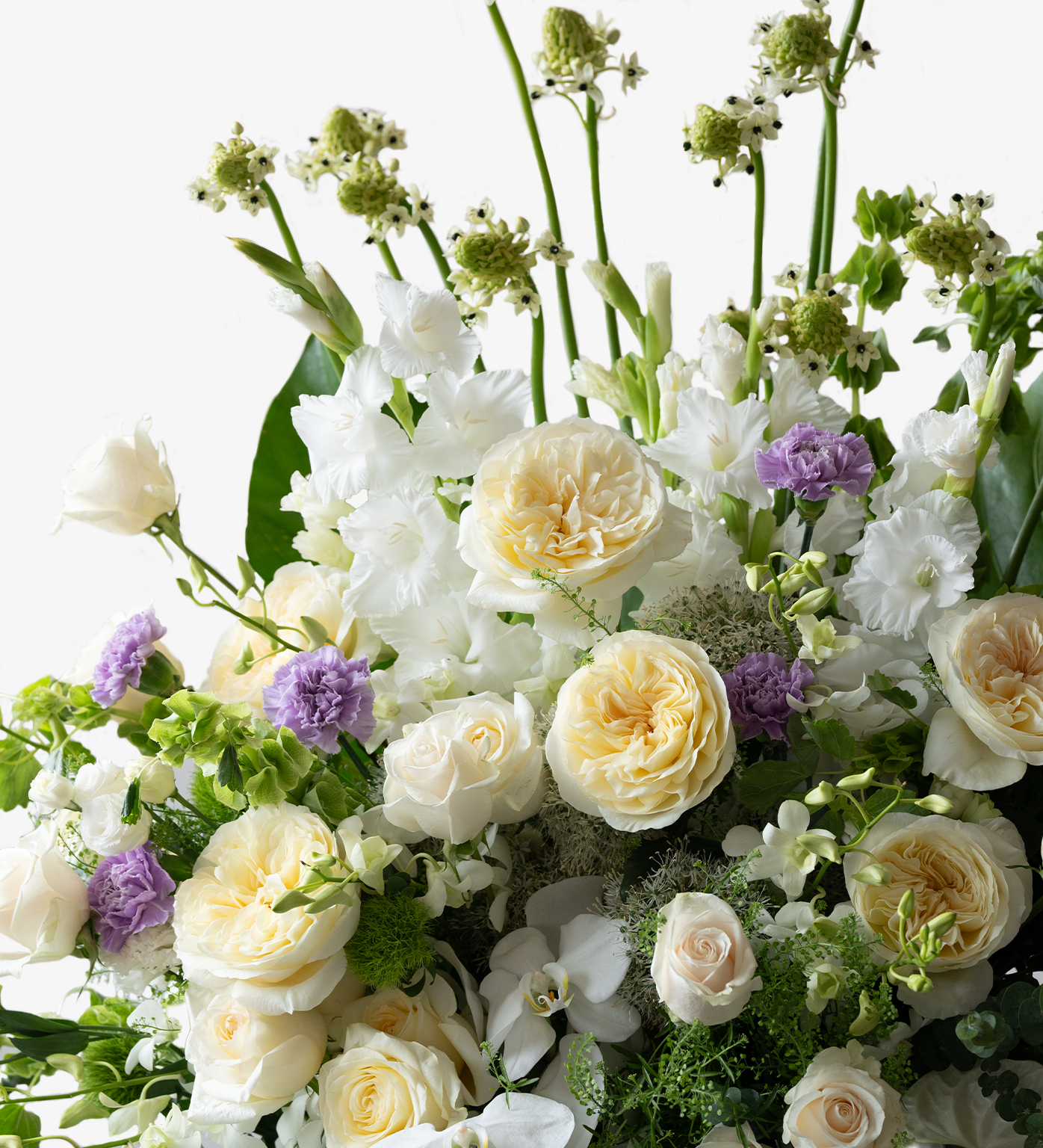 Close-up view of Kindness funeral arrangement showing white roses, moth orchids, and premium floral details