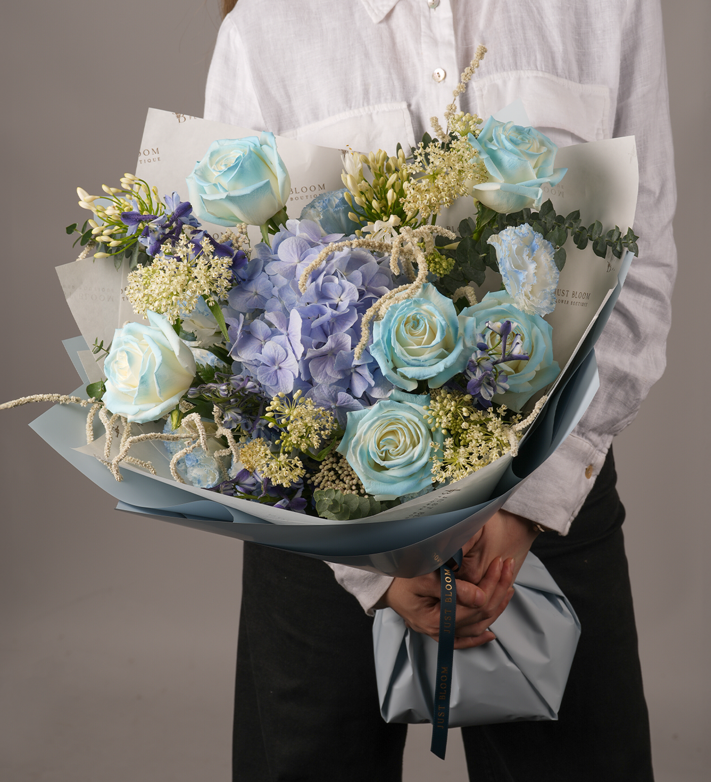 Close-up view of Legacy bouquet showing blue roses, hydrangeas, and golden accent flowers
