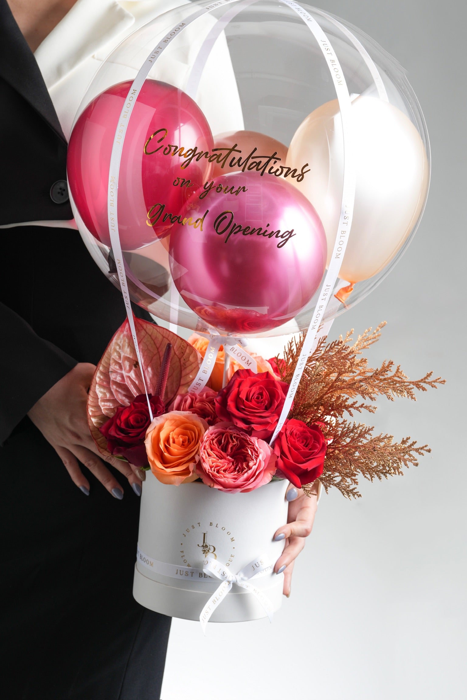 Close-up view of Liberty flower arrangement showing premium roses, anthuriums, and golden foliage details