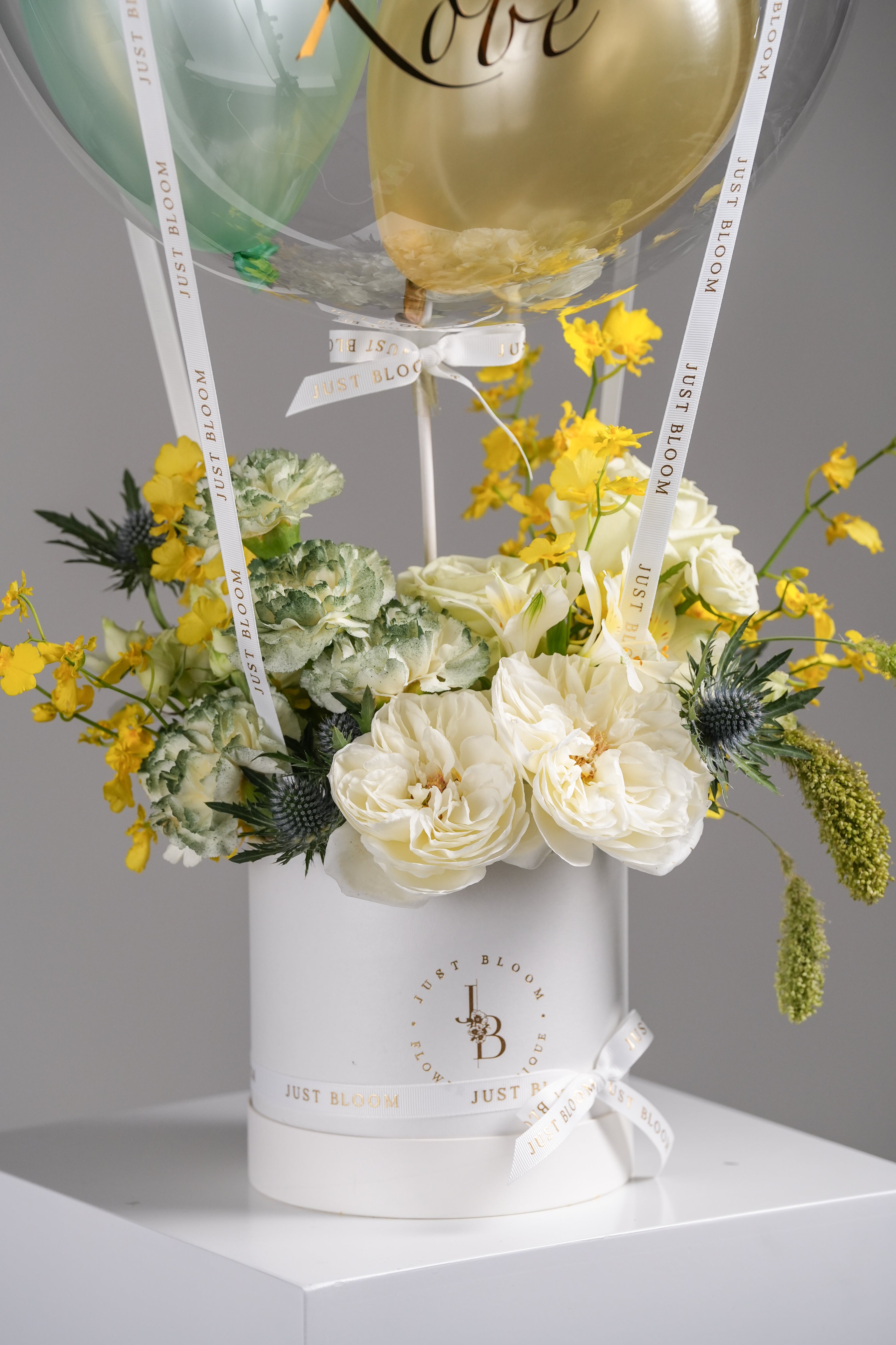 Close-up view of Linnea flower arrangement showing white roses, dancing orchids, and green-yellow filler flowers