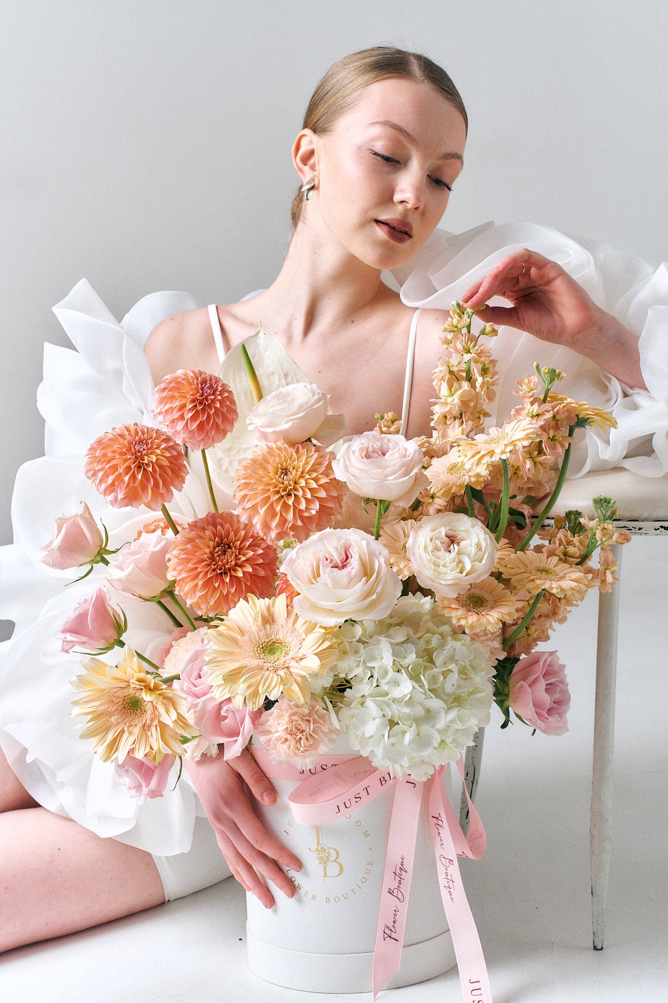 Love at First Sight large romantic flower box with blush roses and peach dahlias held by woman in white