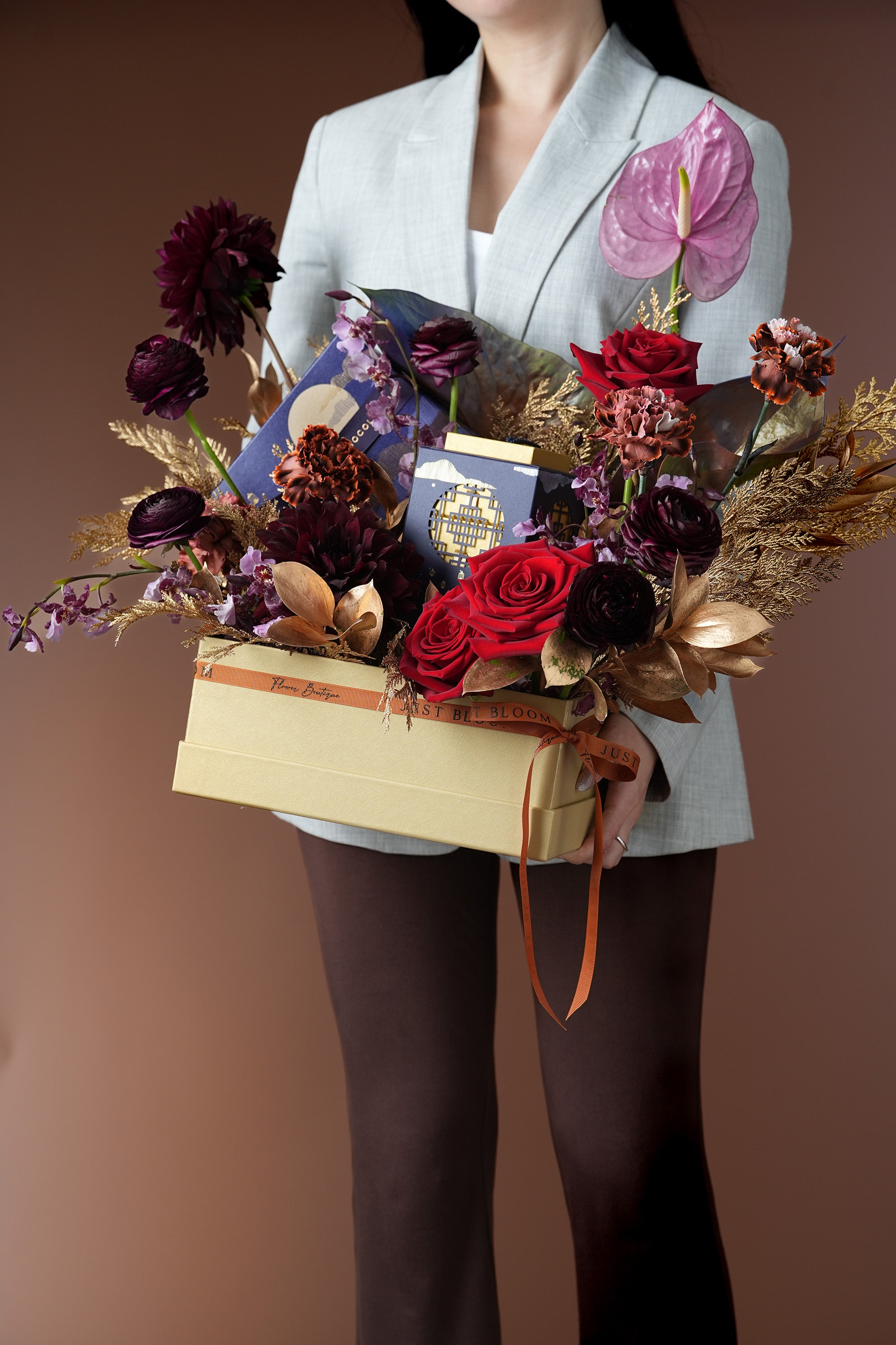 Lunar Elegance Mid-Autumn floral gift box held in hands, styled with rich flowers and chocolate box