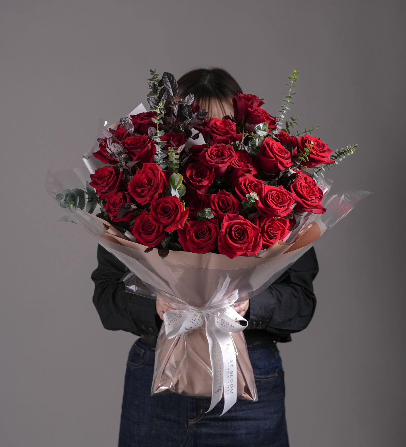 Lyla luxury bouquet of red Ecuadorian garden roses with eucalyptus wrapped in champagne and clear paper