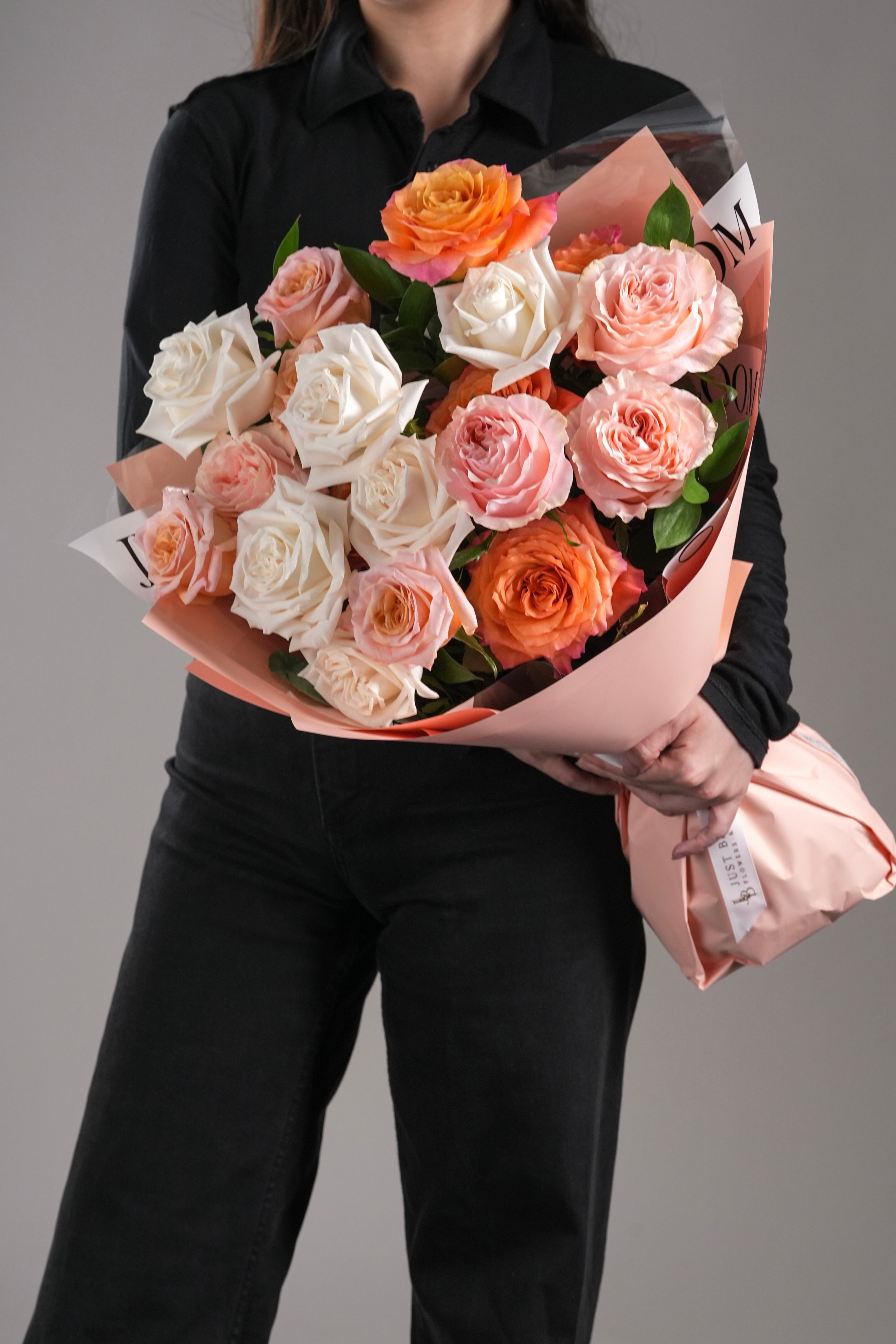 Mace bouquet with pastel peach and orange Ecuadorian roses wrapped in peach and sheer paper