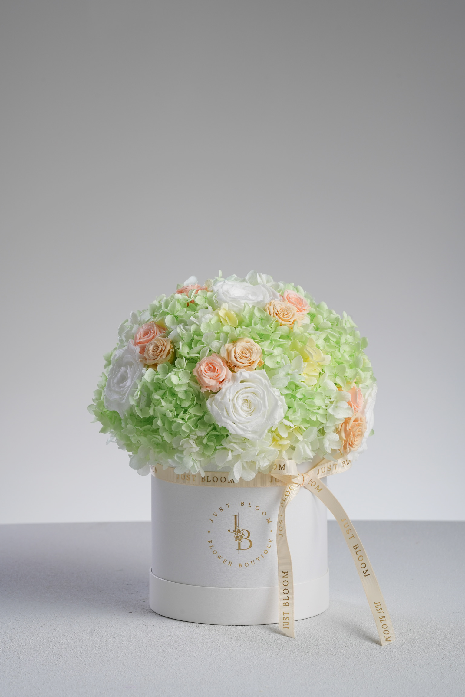 Mara - A preserved flower box with ivory roses, pastel green hydrangeas, and peach accents. A refreshing and elegant floral gift by Just Bloom HK