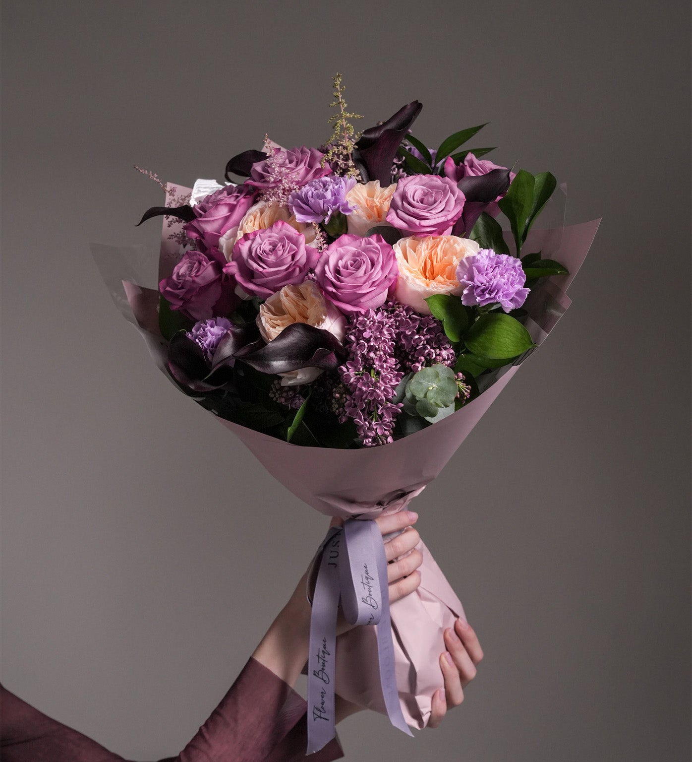 Close-up of Maternal Grace bouquet featuring roses, Juliet garden roses, carnations, and astilbes