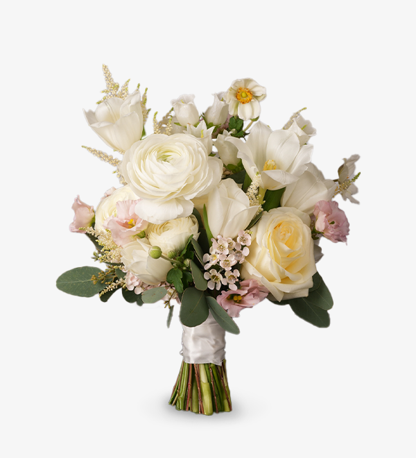 Meadow bridal bouquet with white roses, ranunculus, tulips, astilbes, and eustomas