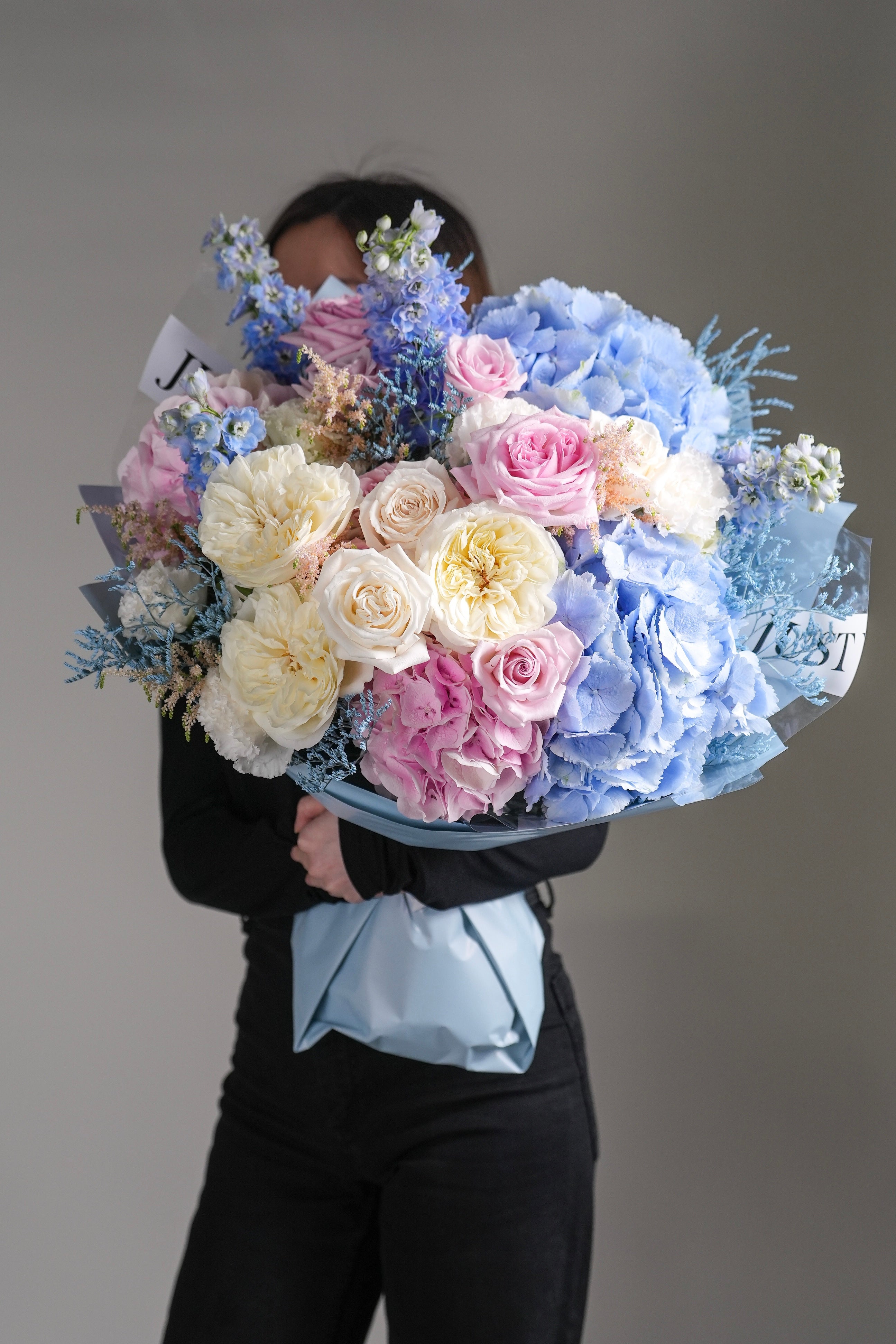 Mia bouquet featuring hydrangeas, pink roses, white roses, and soft blue delphiniums
