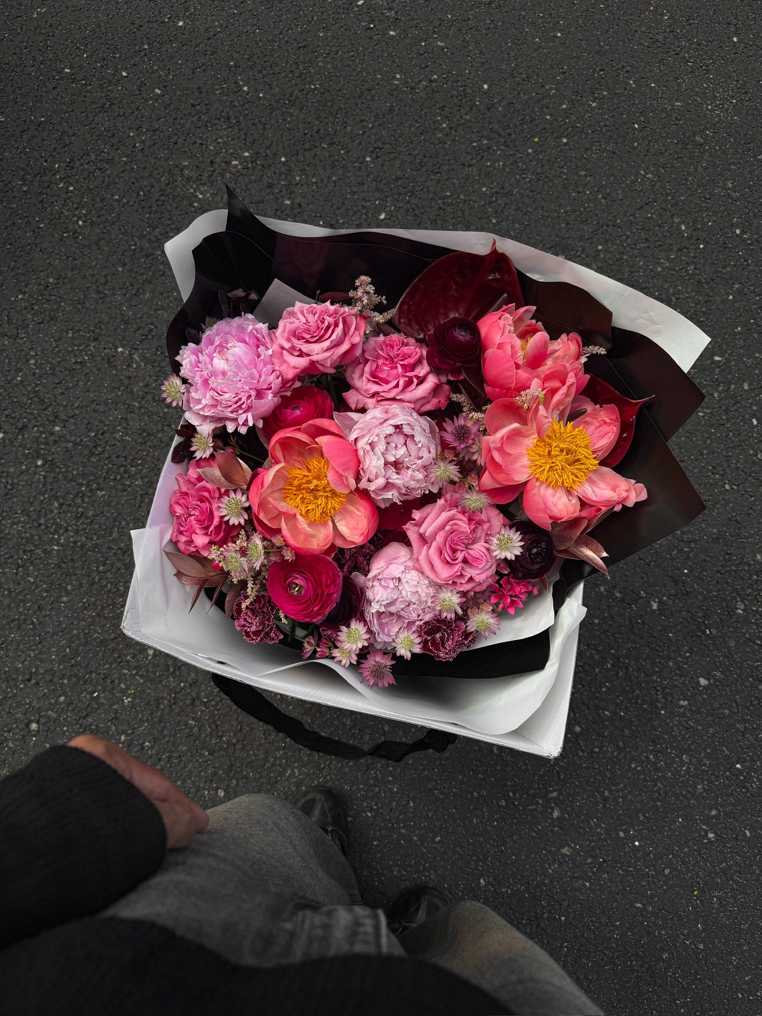 Midnight Peonies luxury bouquet by Just Bloom Hong Kong photographed from above, showcasing the full arrangement of deep pink peonies, coral ranunculus, roses and burgundy carnations in black and white wrapping