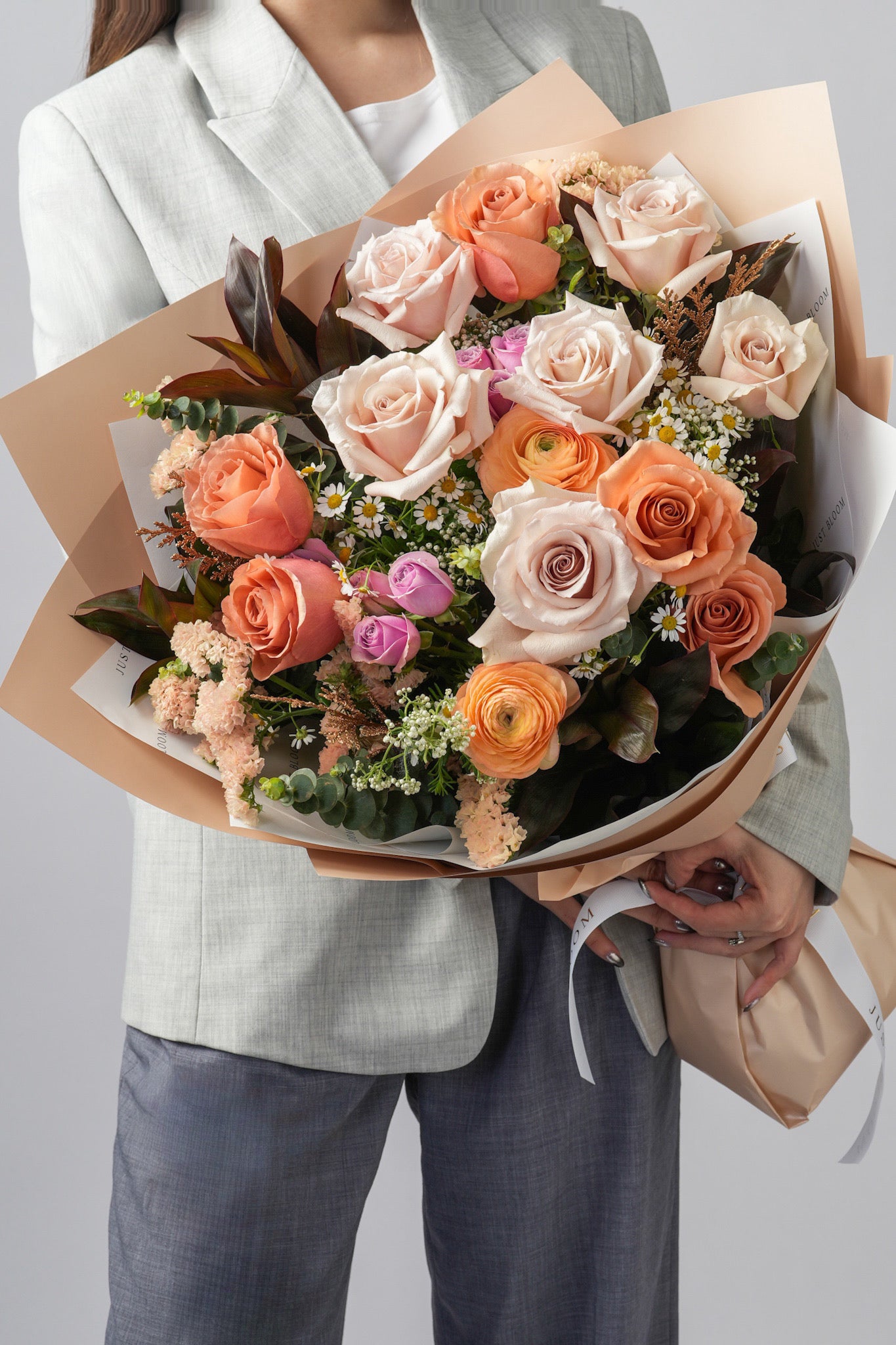 Close-up of Mocha bouquet showing earth tone roses, ranunculus, and greenery