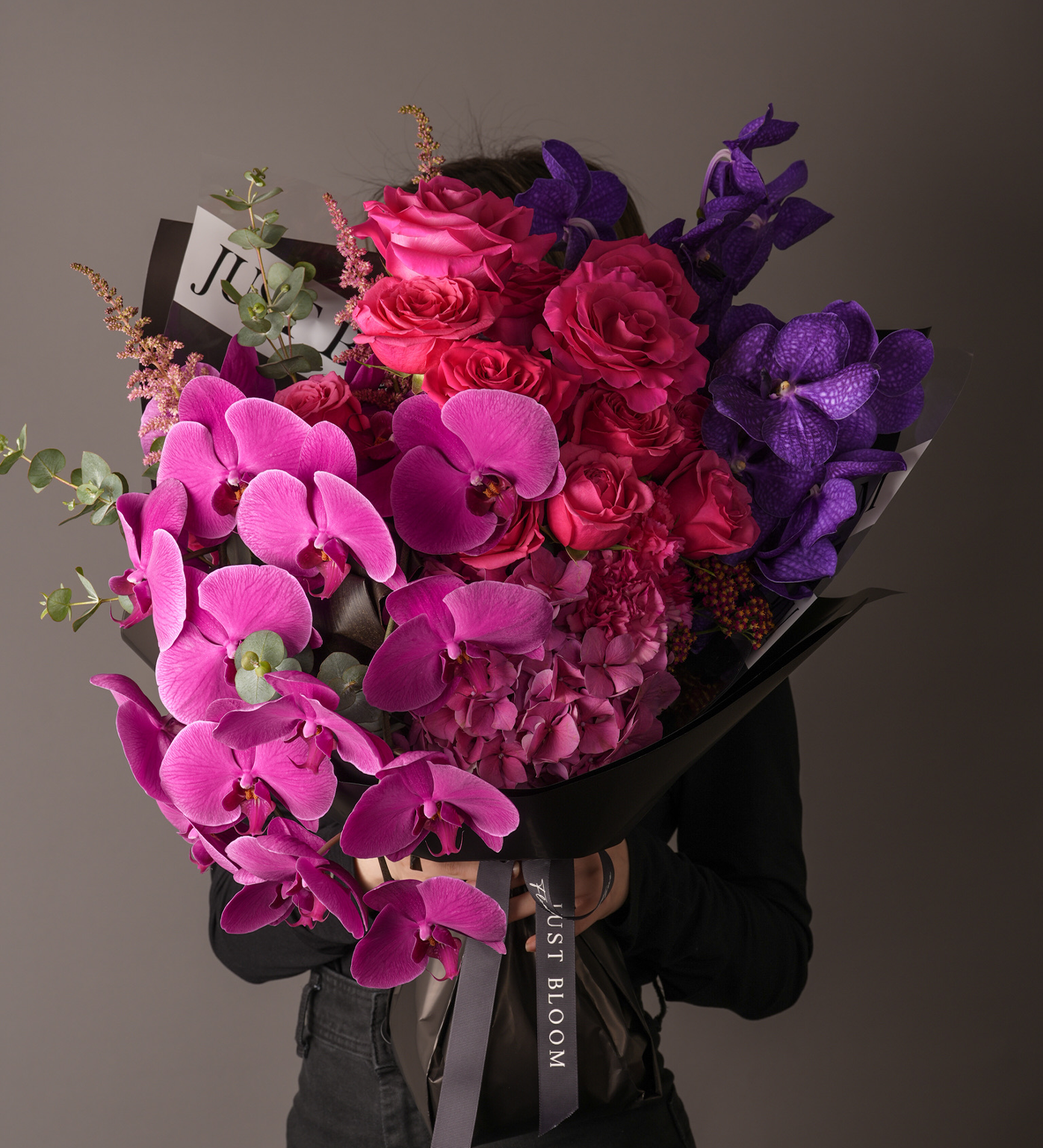 Monroe bouquet with purple orchids, pink roses and hydrangeas wrapped in black