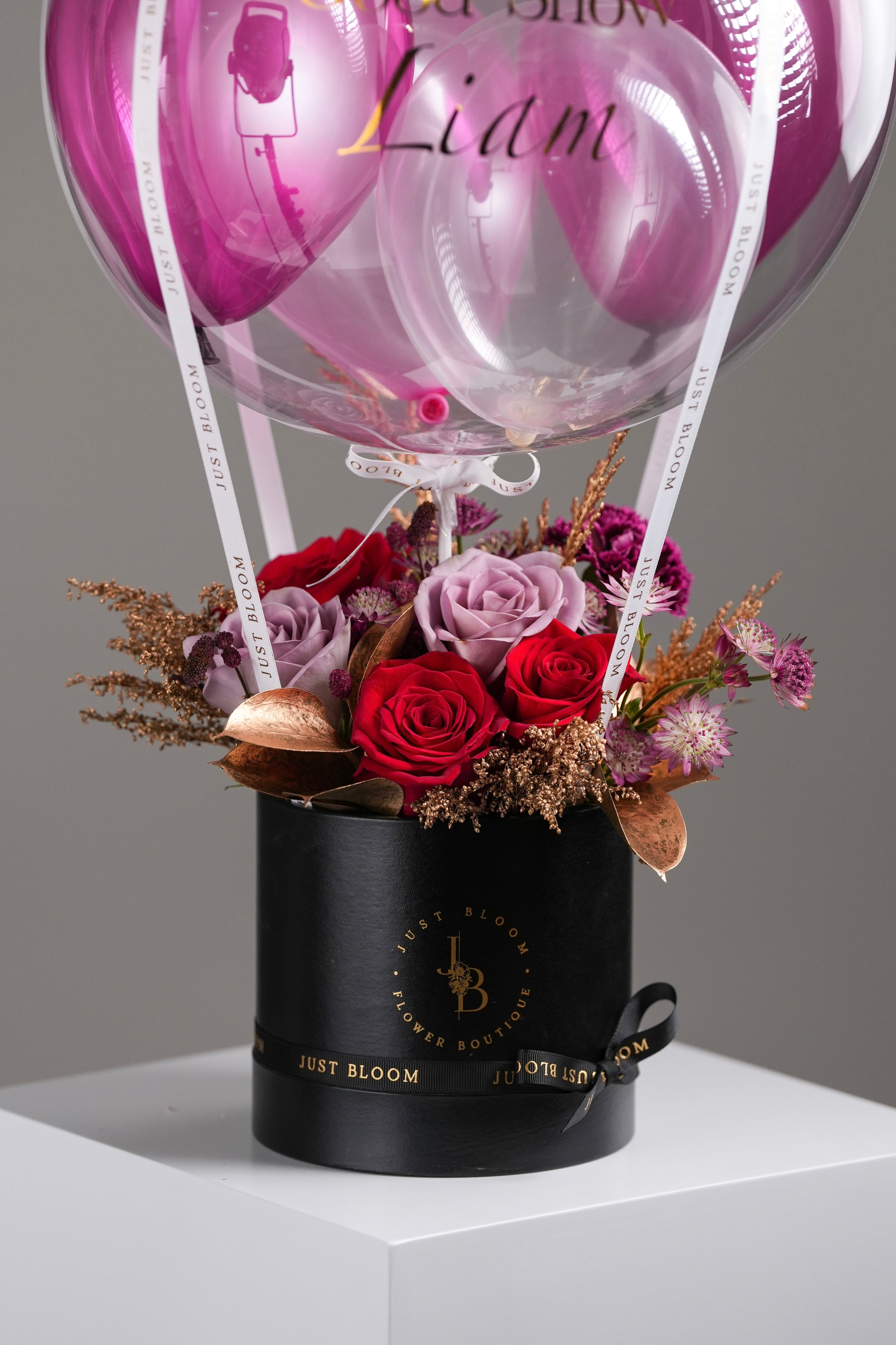 Mulberry arrangement close-up showing roses, orchids and crystal balloon in black box