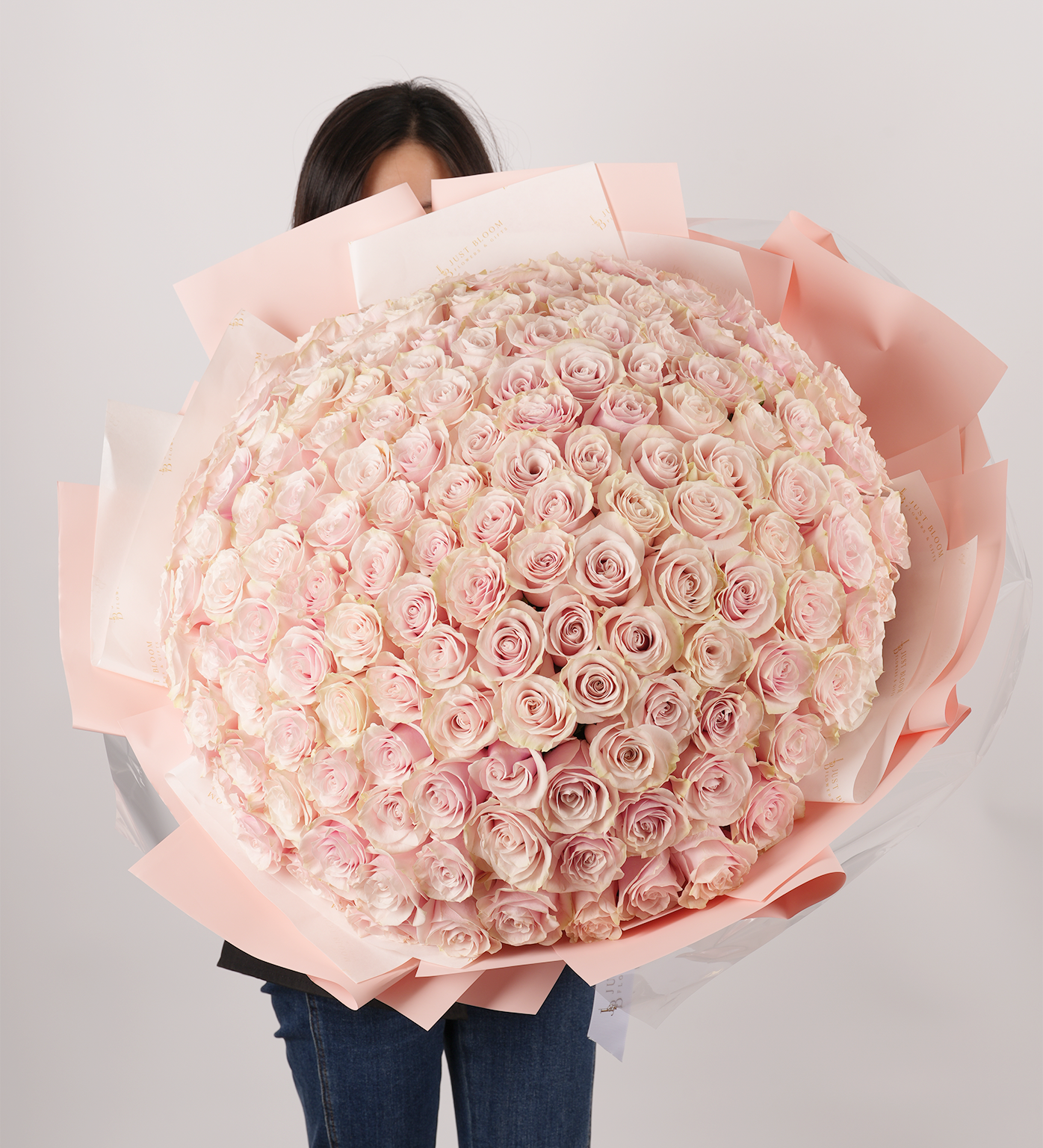 Natalie bouquet held by model featuring soft pink dome arrangement