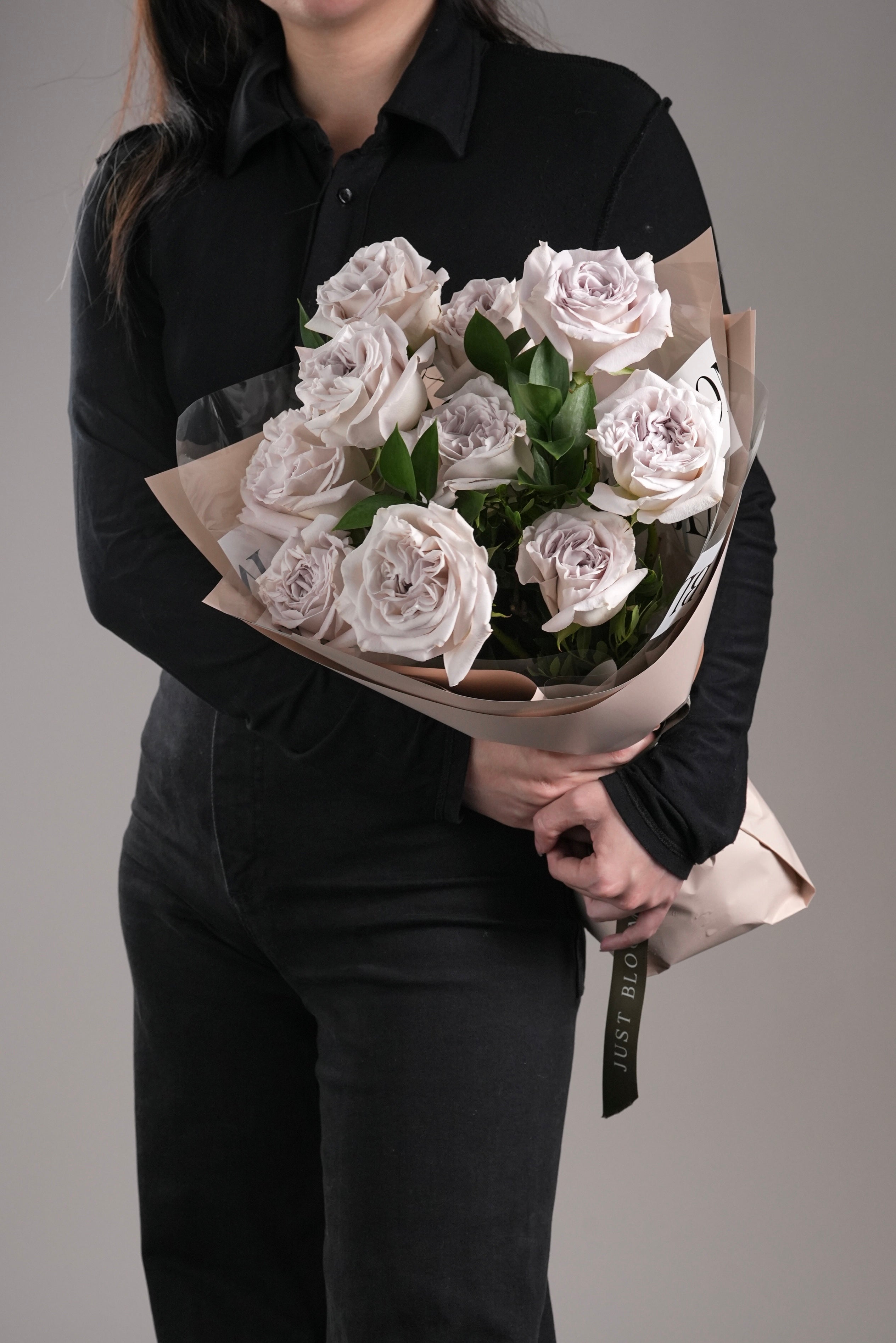 Person holding Ophelia grey rose bouquet wrapped in beige paper – front view | Just Bloom Hong Kong