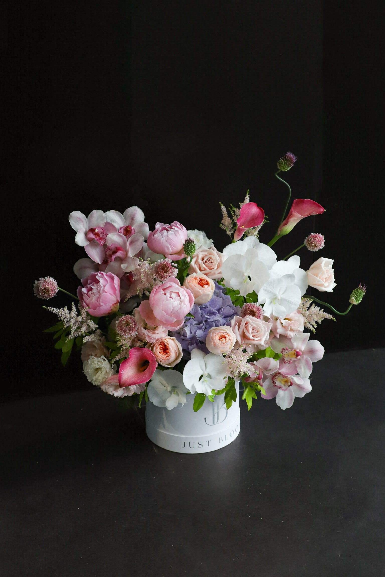 Opulence luxury flower box by Just Bloom Hong Kong featuring peonies, phalaenopsis orchids, calla lilies, hydrangeas and cymbidium orchids overflowing from a signature white Just Bloom hat box