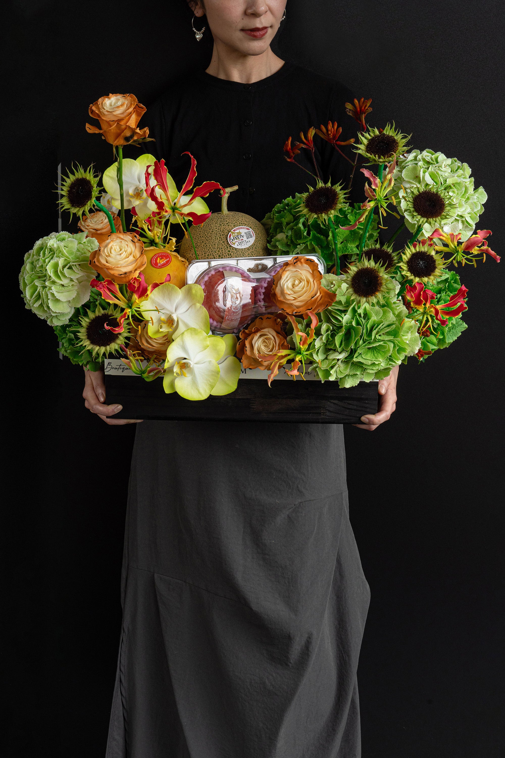 Model holding Just Bloom Orchard Ode flower box with green hydrangeas, sunflowers and seasonal fruit — Just Bloom Hong Kong