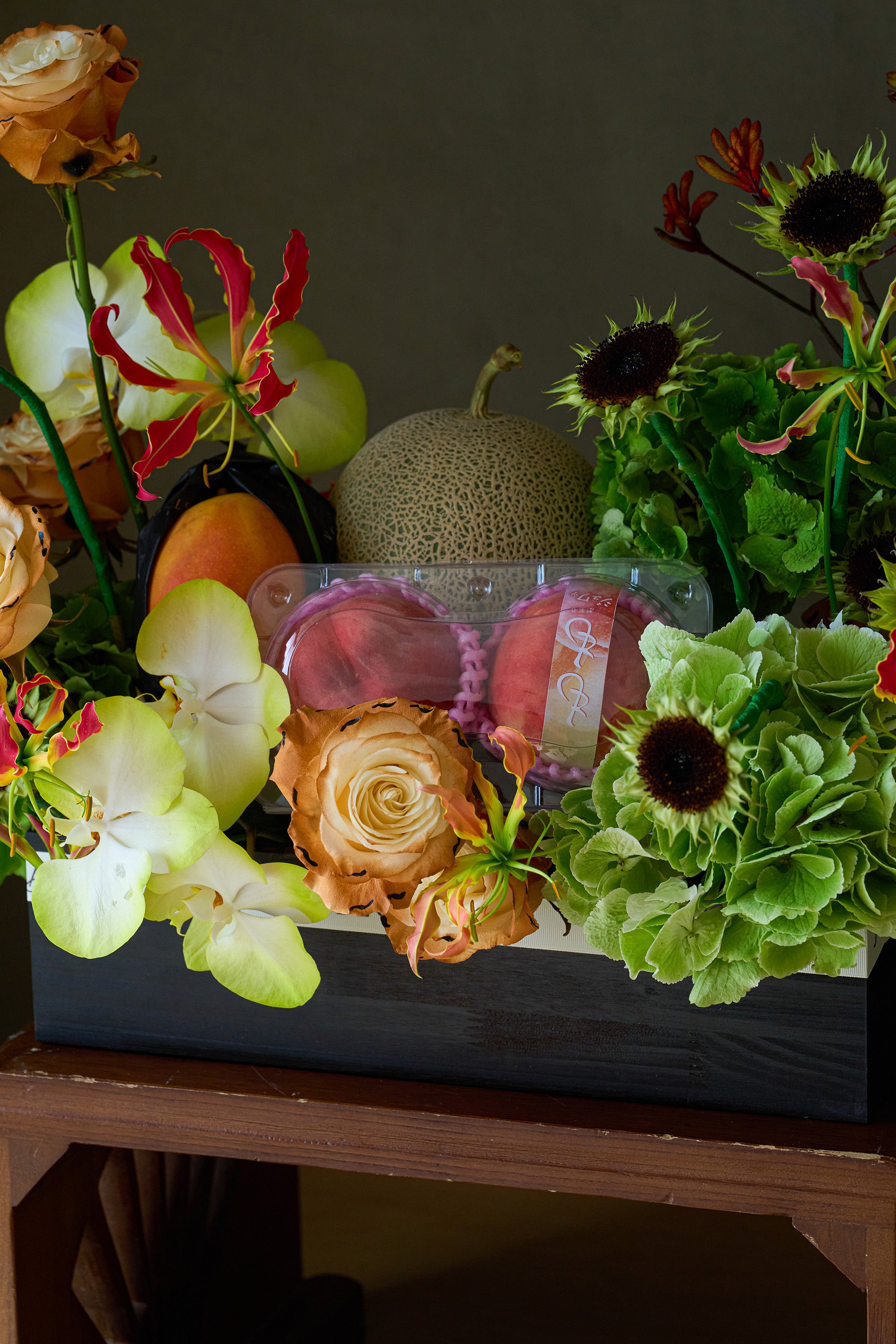 Close-up of Orchard Ode flower box arrangement with melon, peaches and flame lilies — Just Bloom Hong Kong