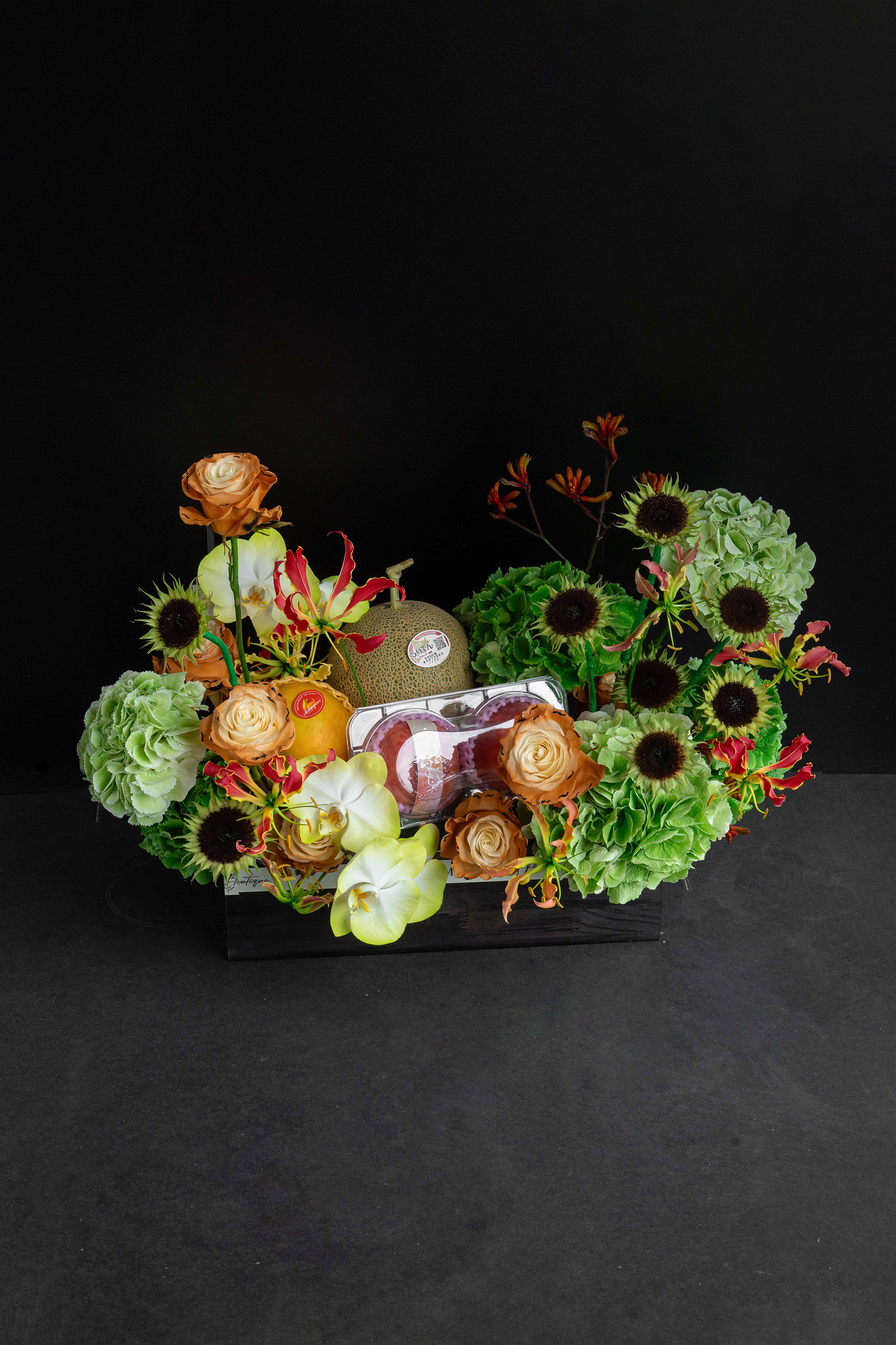 Just Bloom Orchard Ode flower box with green hydrangeas and seasonal fruit against a black background — Just Bloom Hong Kong