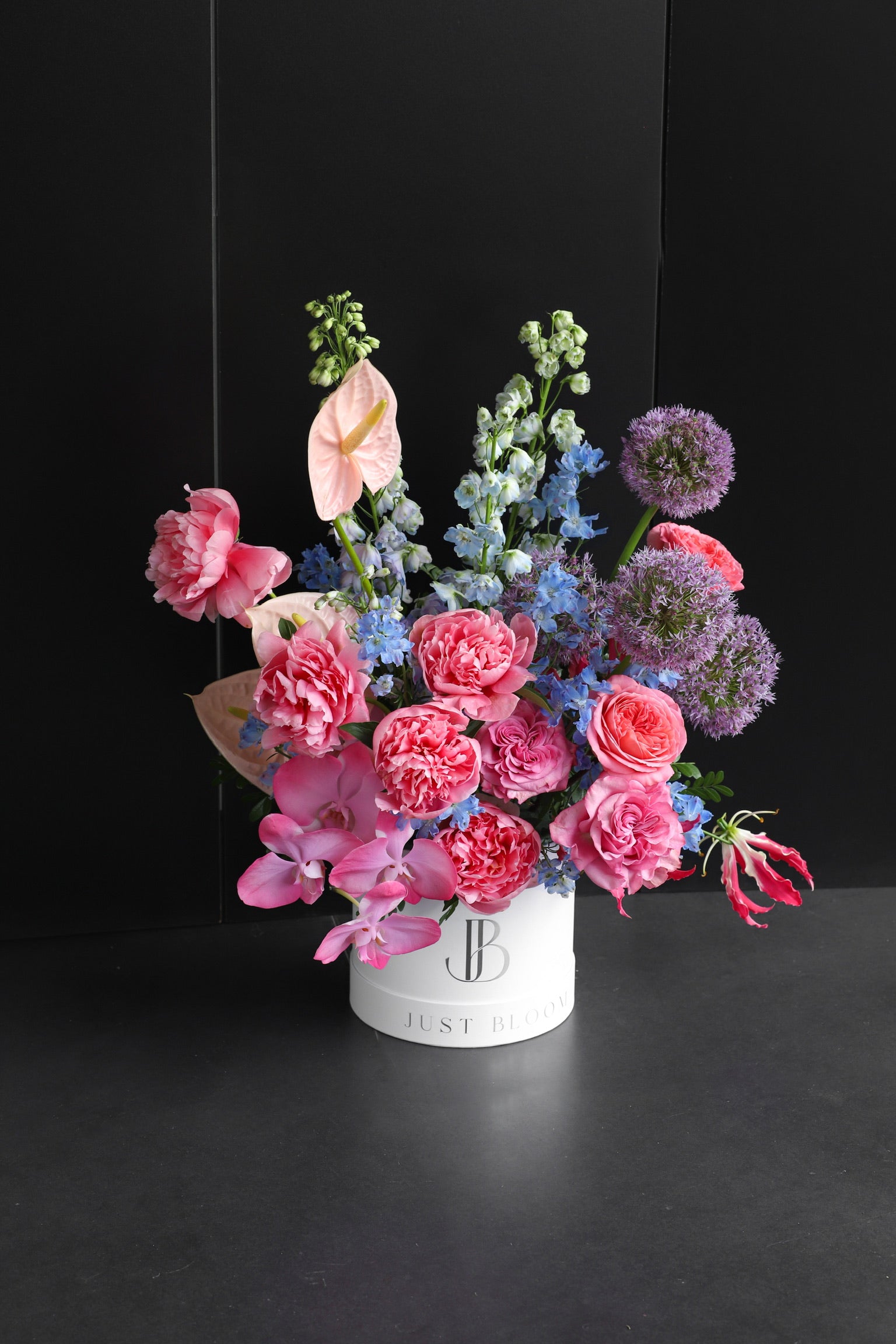 Just Bloom flower box arrangement showing vibrant pink and purple blooms against a dark background — Just Bloom Hong Kong