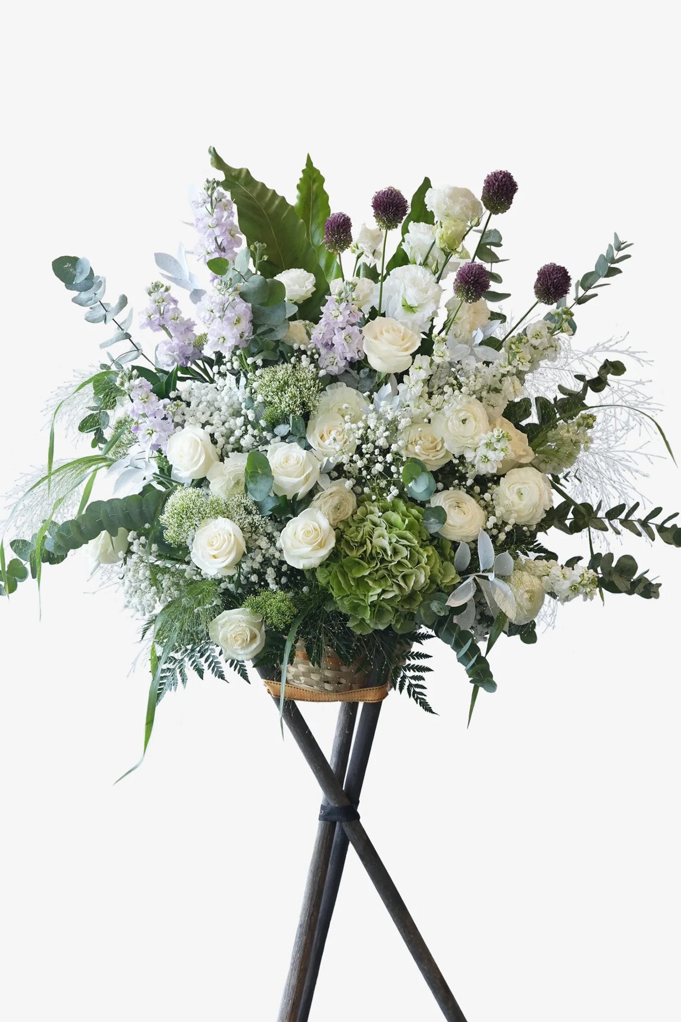 Peaceful Journey flower stand with white roses, green hydrangeas, baby’s breath, and lavender stocks