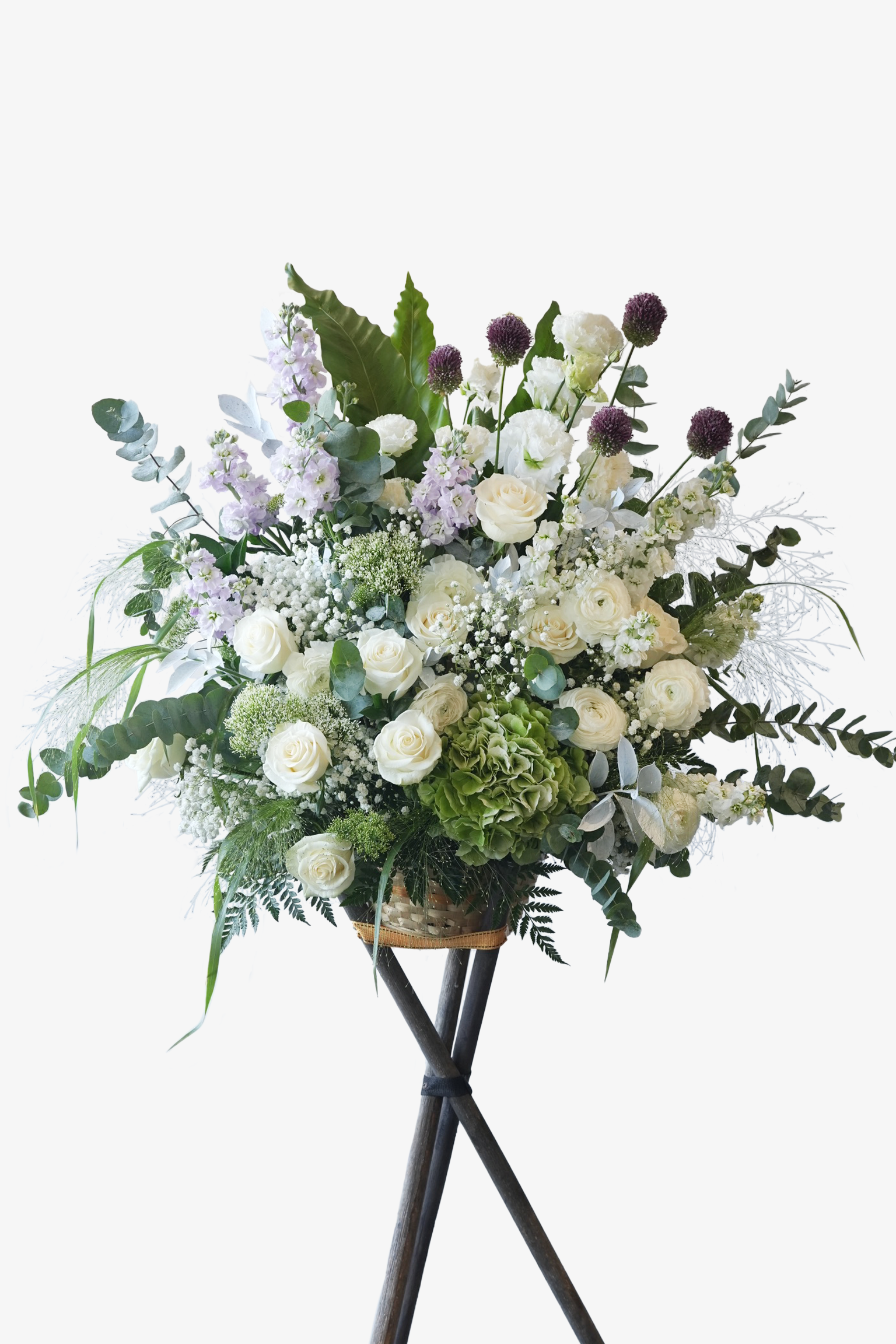 Peaceful Journey flower stand with white roses, green hydrangeas, baby’s breath, and lavender stocks