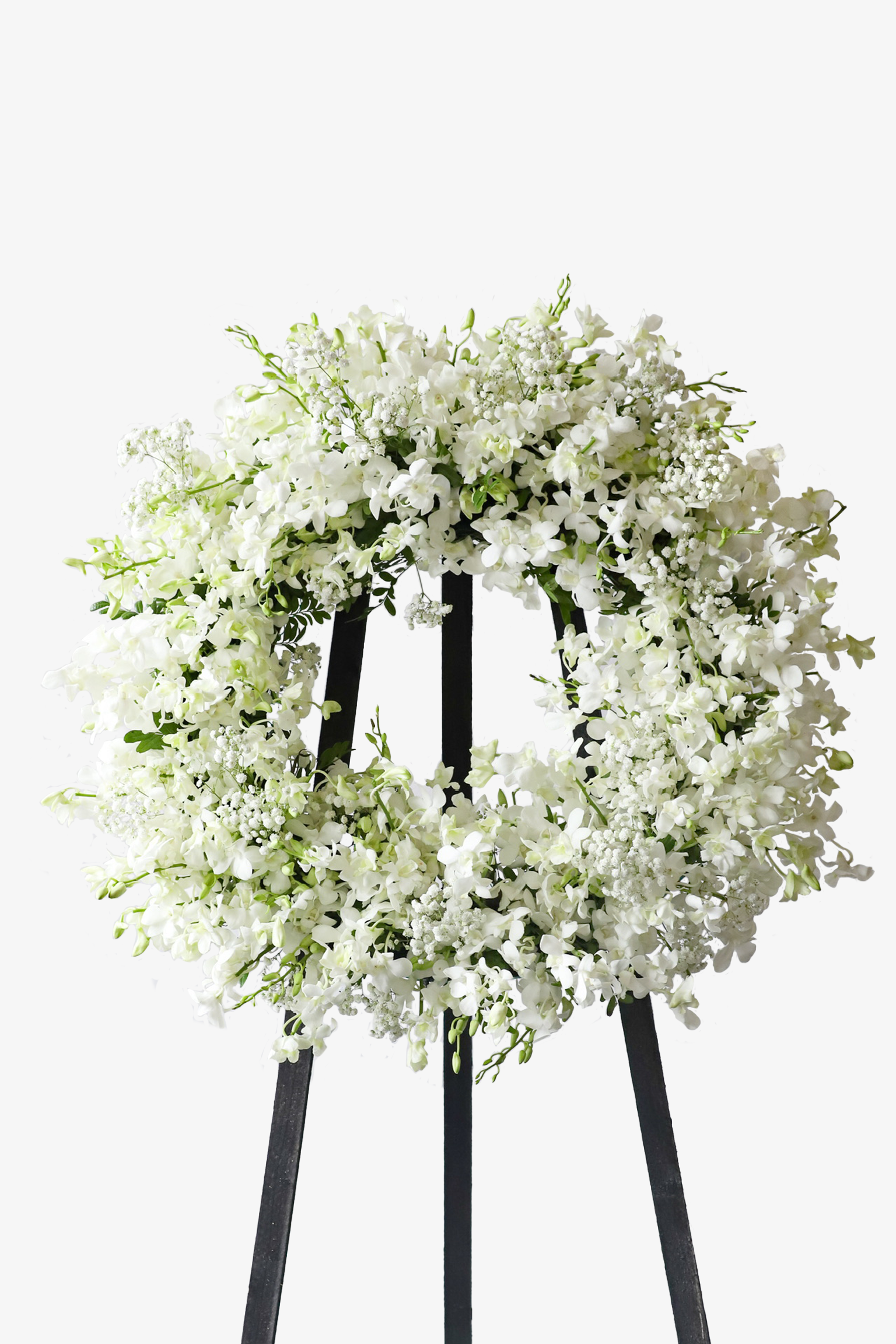 Large all-white condolence floral wreath densely layered with white blooms and delicate fillers, displayed on a black standing frame against a white background — Just Bloom Hong Kong