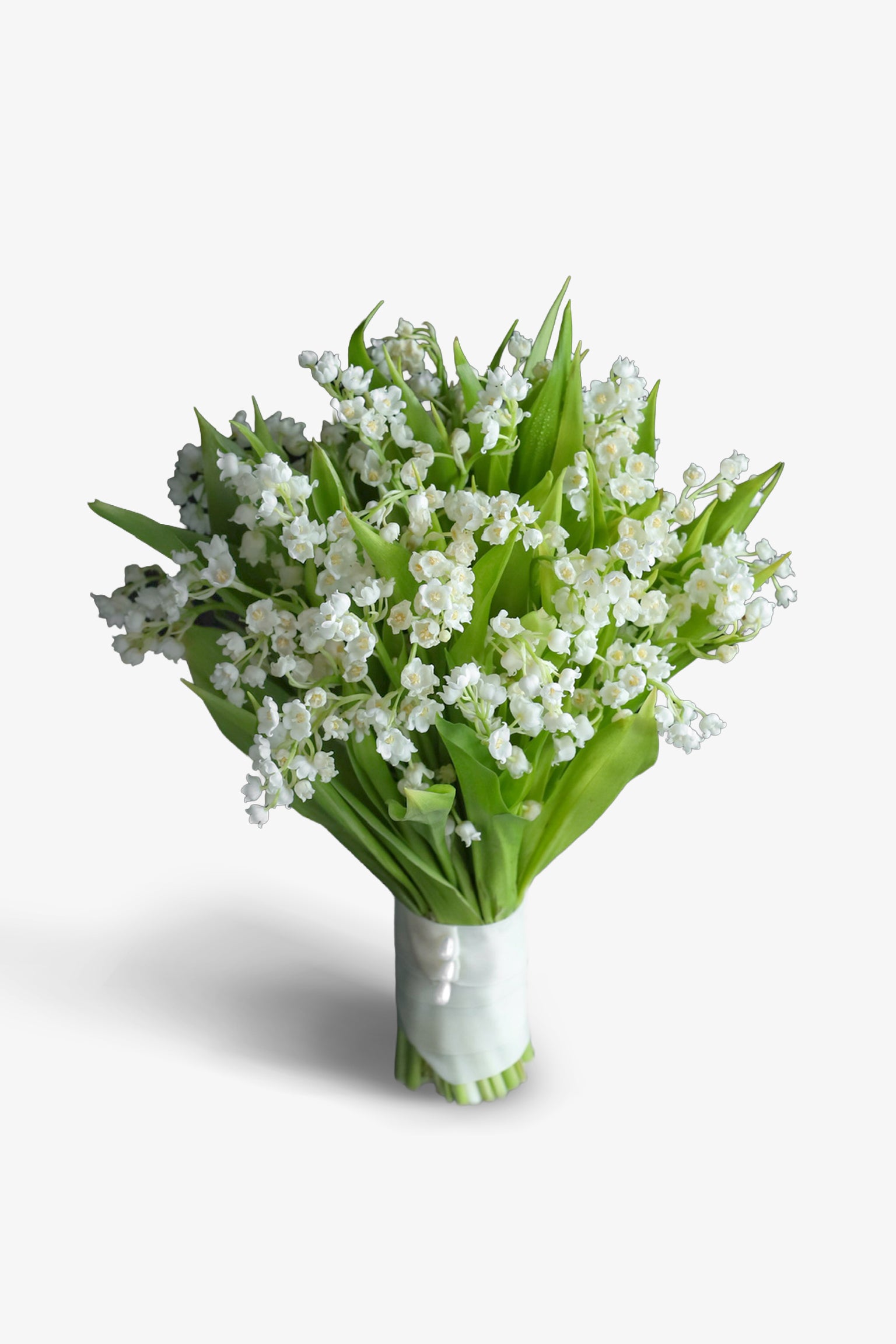 Compact all-Lily of the Valley bridal bouquet with white bell-shaped blooms and deep green leaves, stem wrapped in white satin ribbon, photographed against a dark background — Just Bloom Hong Kong