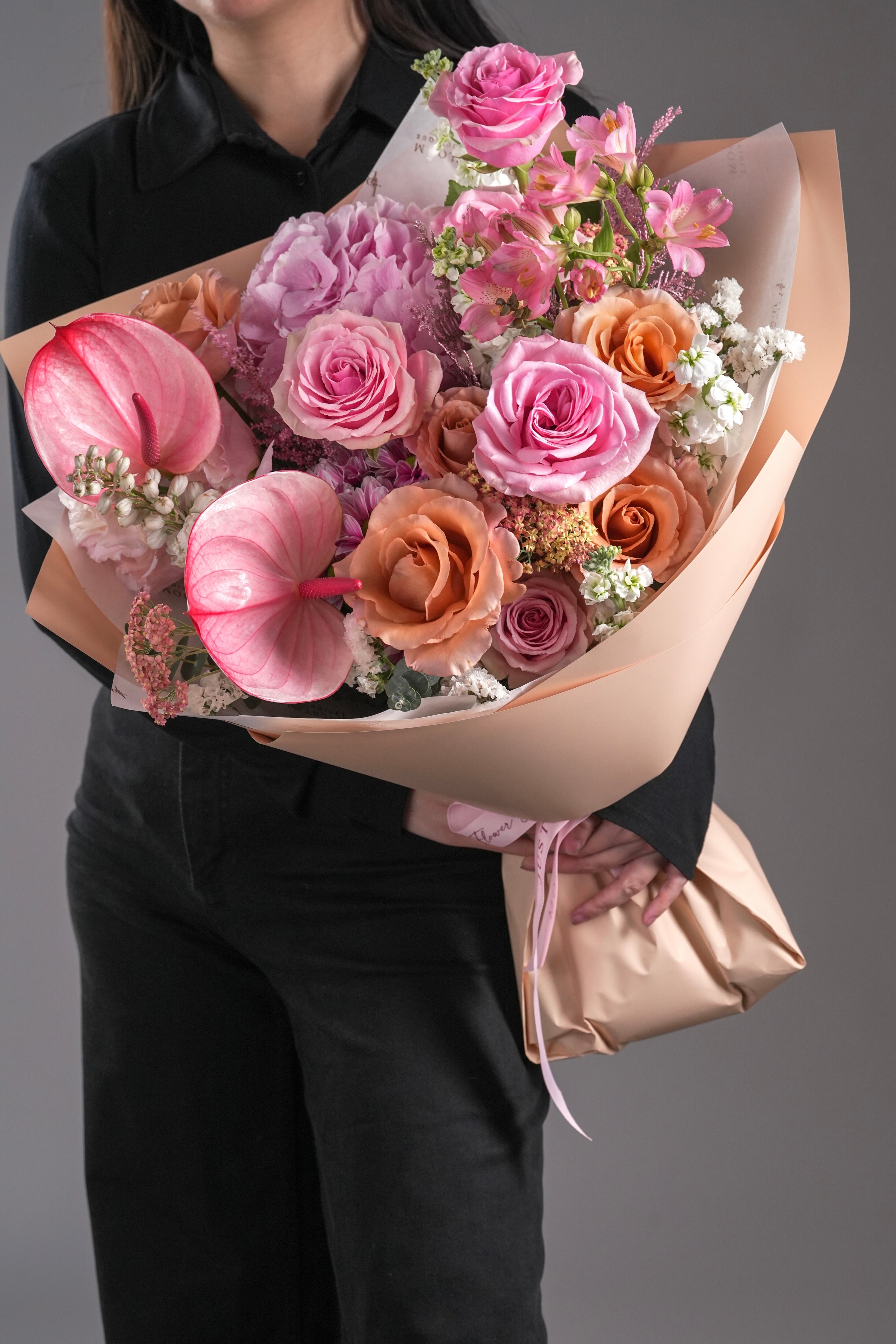 Quinn bouquet side view showing moab roses, hydrangea, and tropical anthuriums