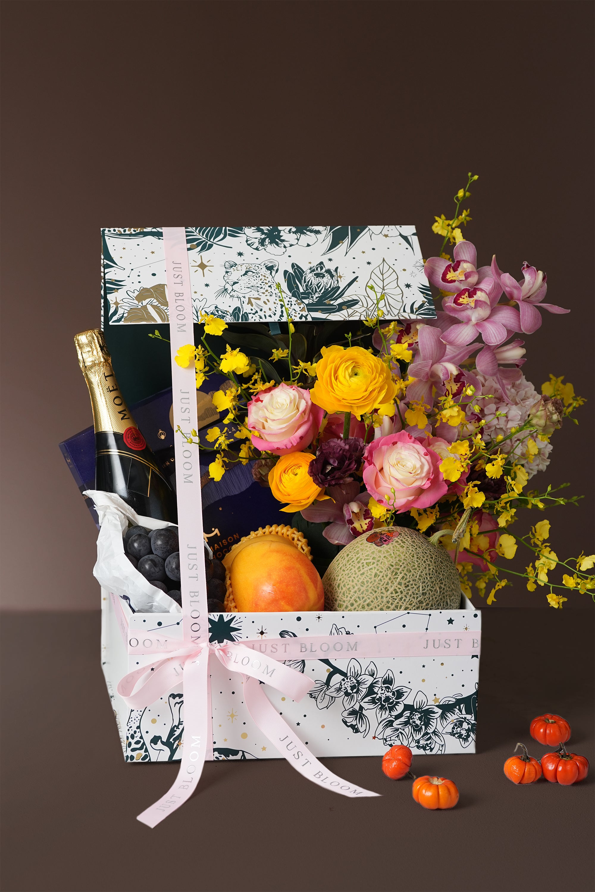 Radiant Harvest Mid-Autumn fruit and floral hamper with cymbidium orchids, roses, ranunculus, melon, papaya, and grapes