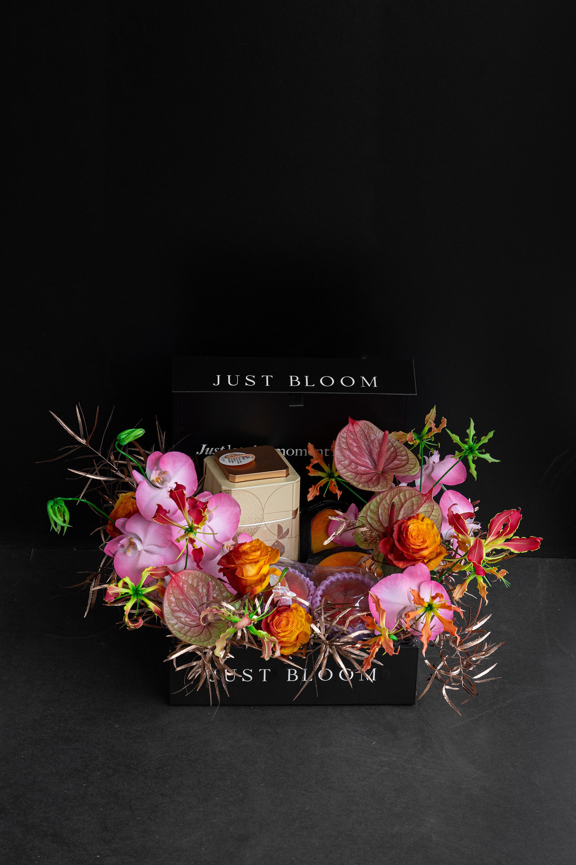 Just Bloom Radiant Reunion flower box with pink orchids and orange roses against a black background — Just Bloom Hong Kong