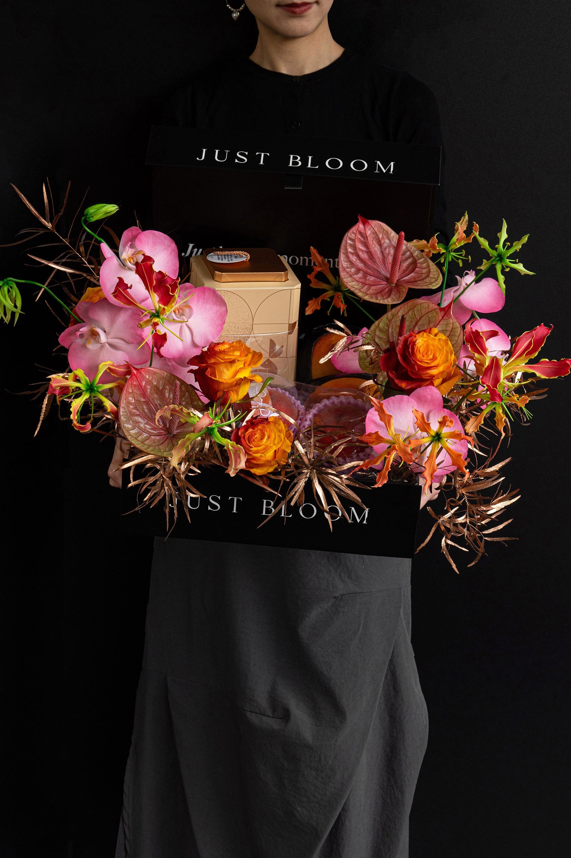 Model holding Just Bloom Radiant Reunion flower box with pink orchids and orange roses — Just Bloom Hong Kong