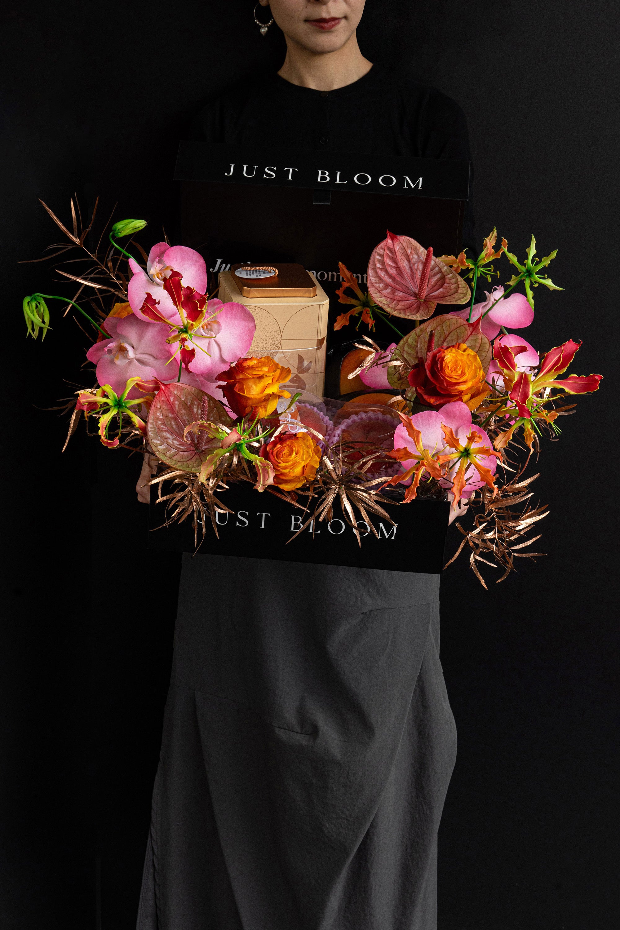 Model holding Just Bloom Radiant Reunion flower box with pink orchids and orange roses — Just Bloom Hong Kong
