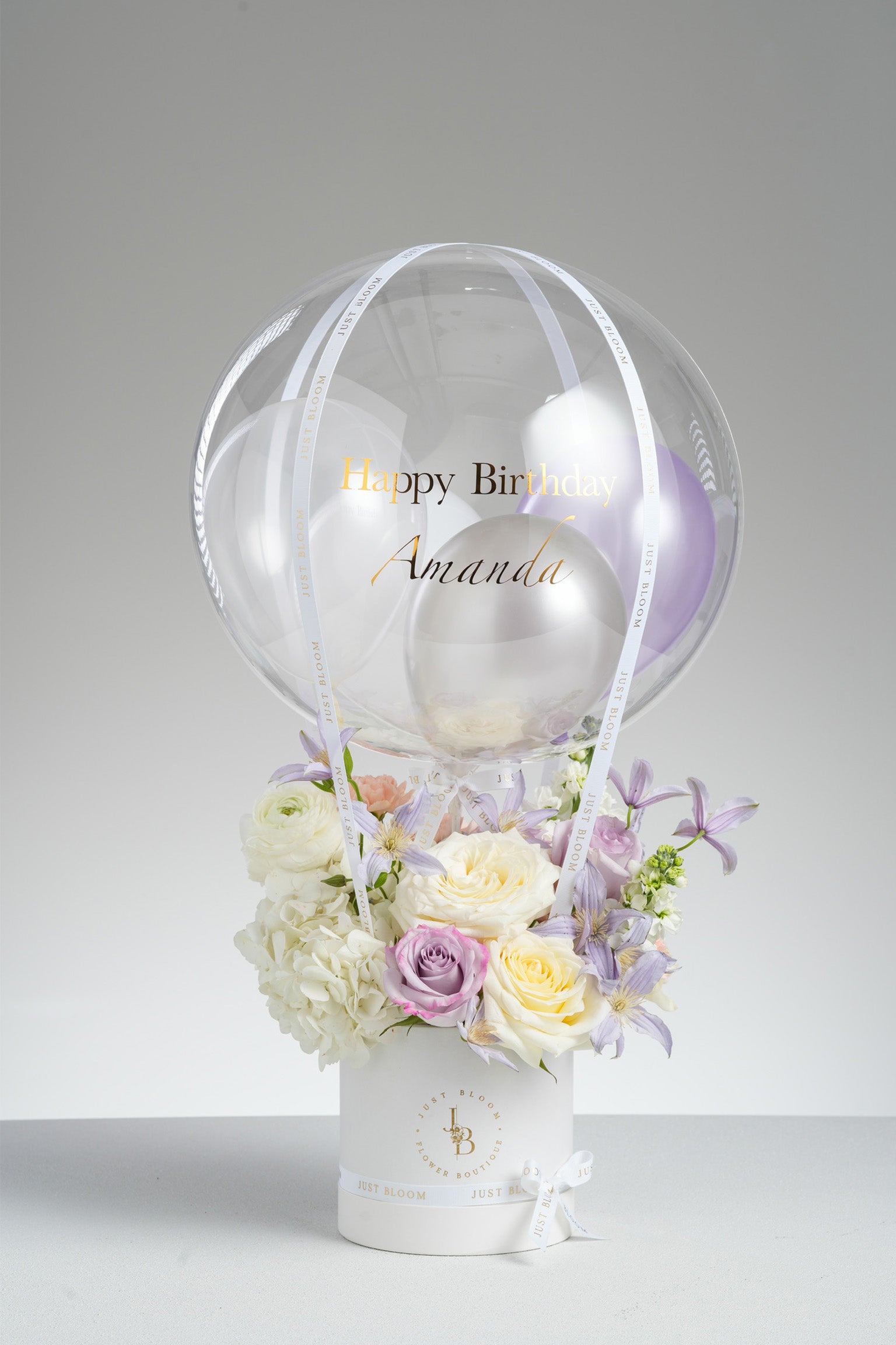 Samara balloon flower box with lavender roses, hydrangeas, and cream eustomas