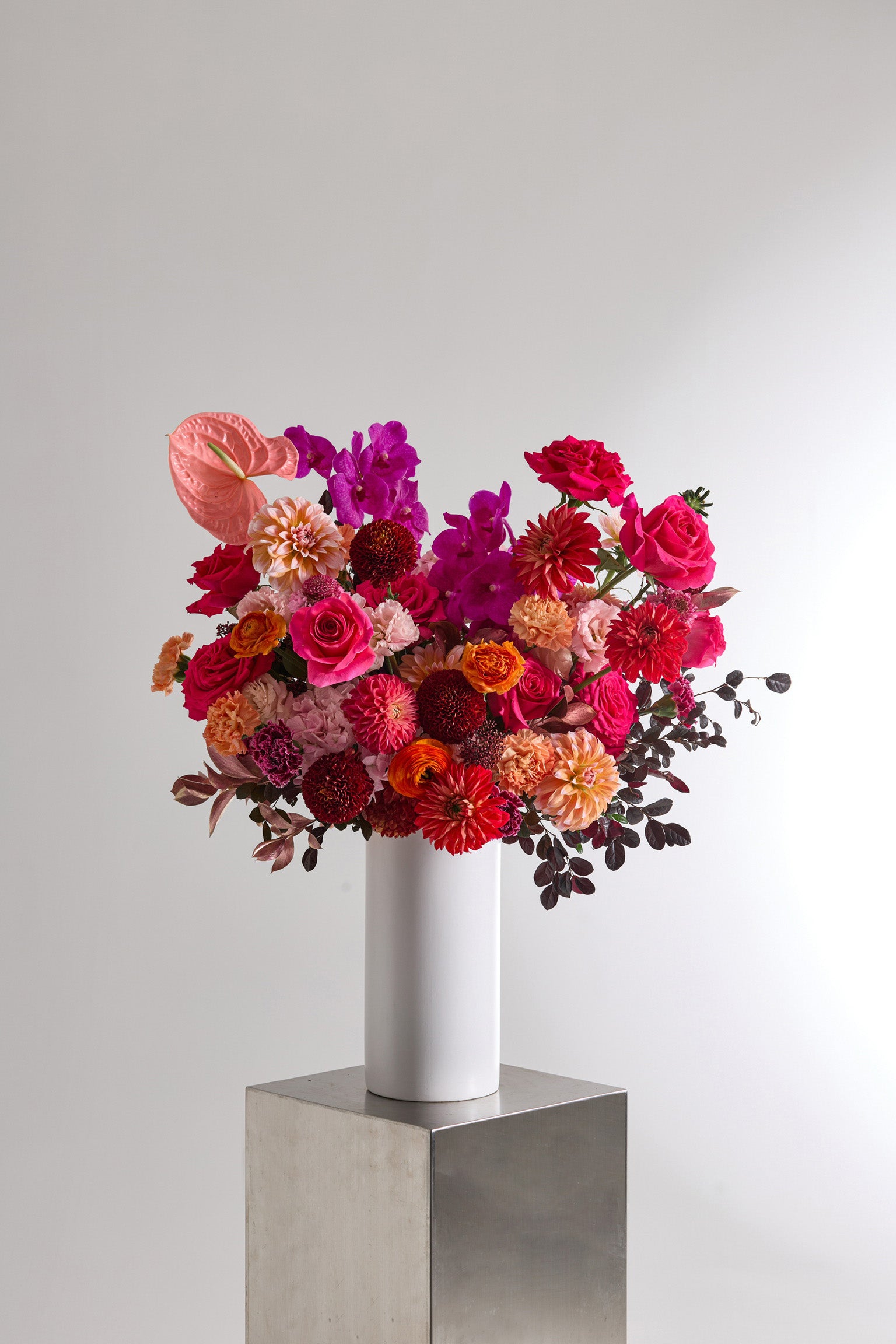 Scarlet Assembly red and magenta vase arrangement with roses dahlias and anthuriums
