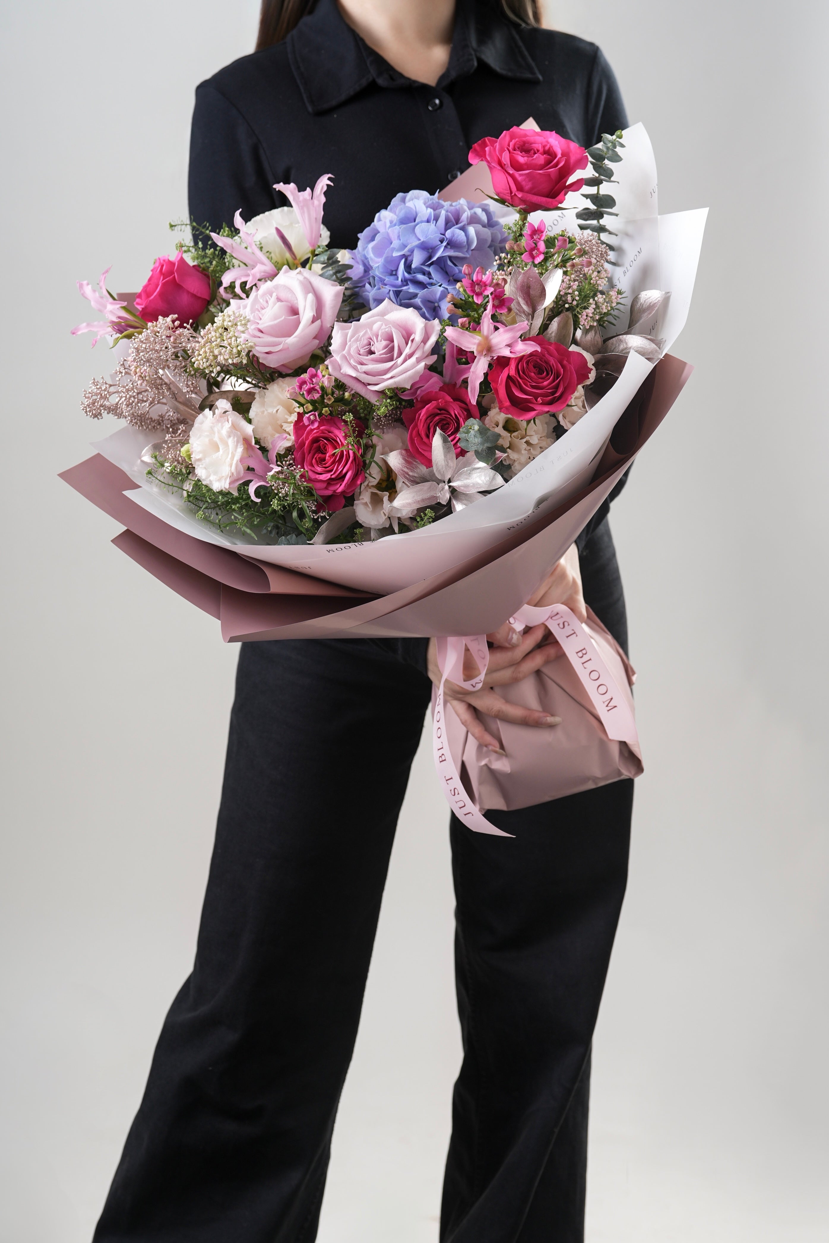 Sienna bouquet with pink roses, purple hydrangeas, and hot pink roses