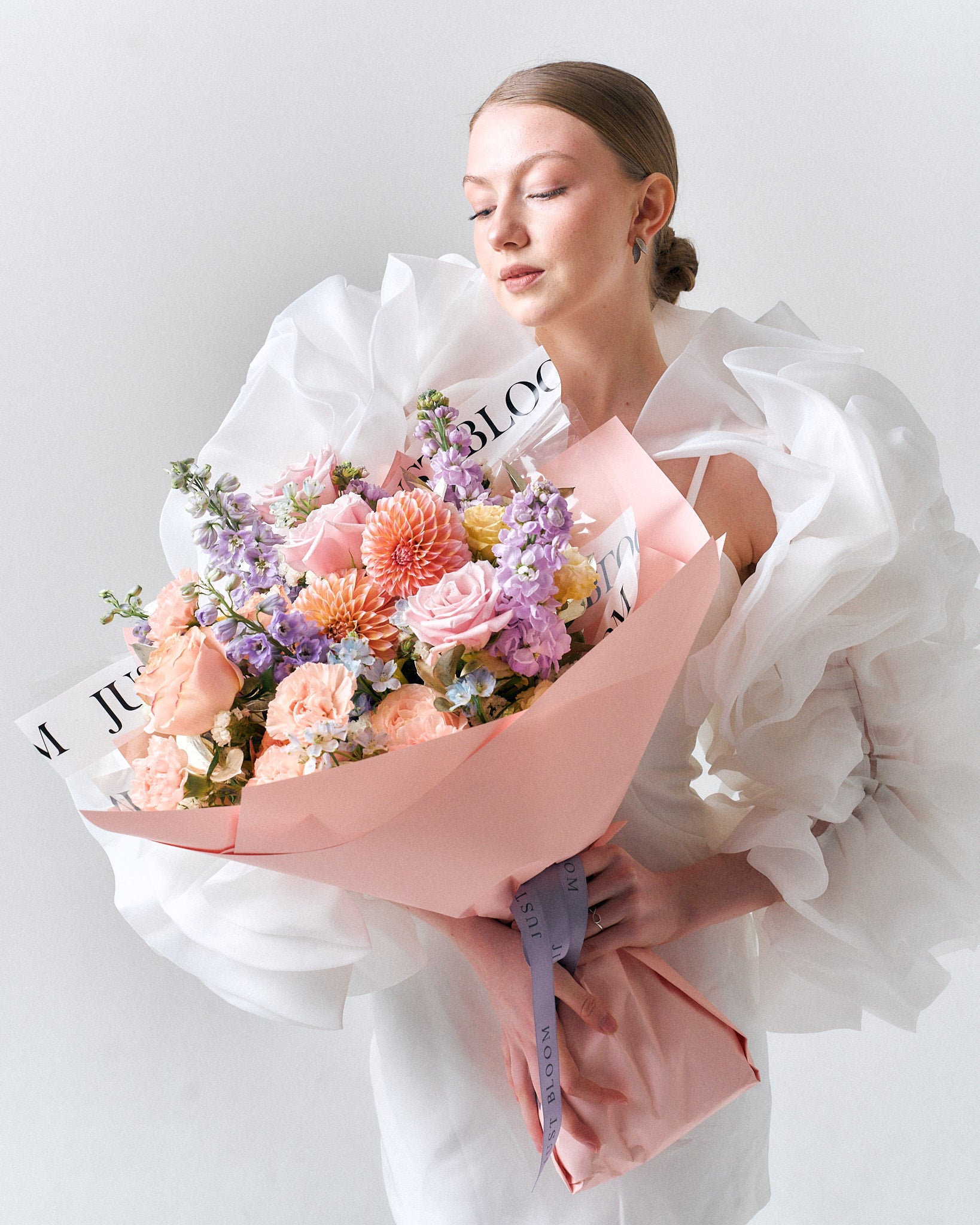 Sweet Encounter bouquet with blush pink roses, peach carnations, lilac stock, and dahlia in pastel tones