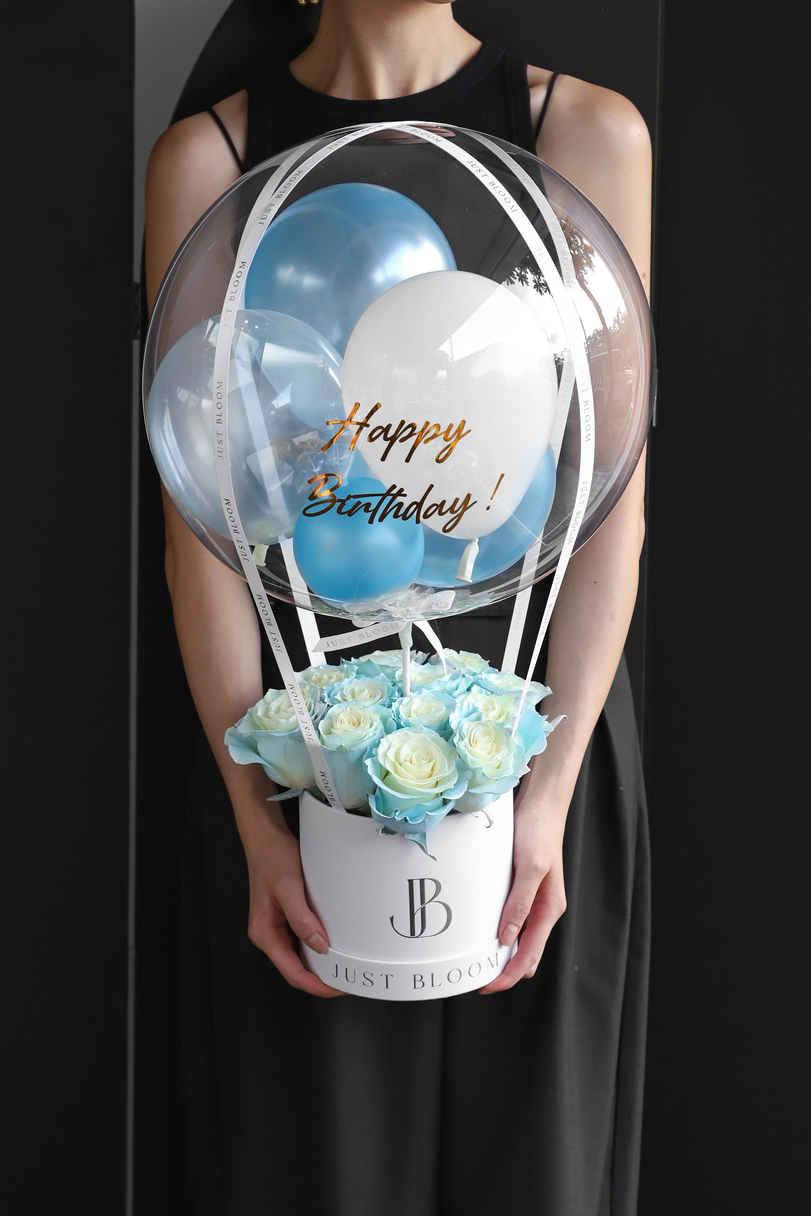 Model holding an all-tinted blue rose flower box in a white Just Bloom round box against a dark background — Just Bloom Hong Kong
