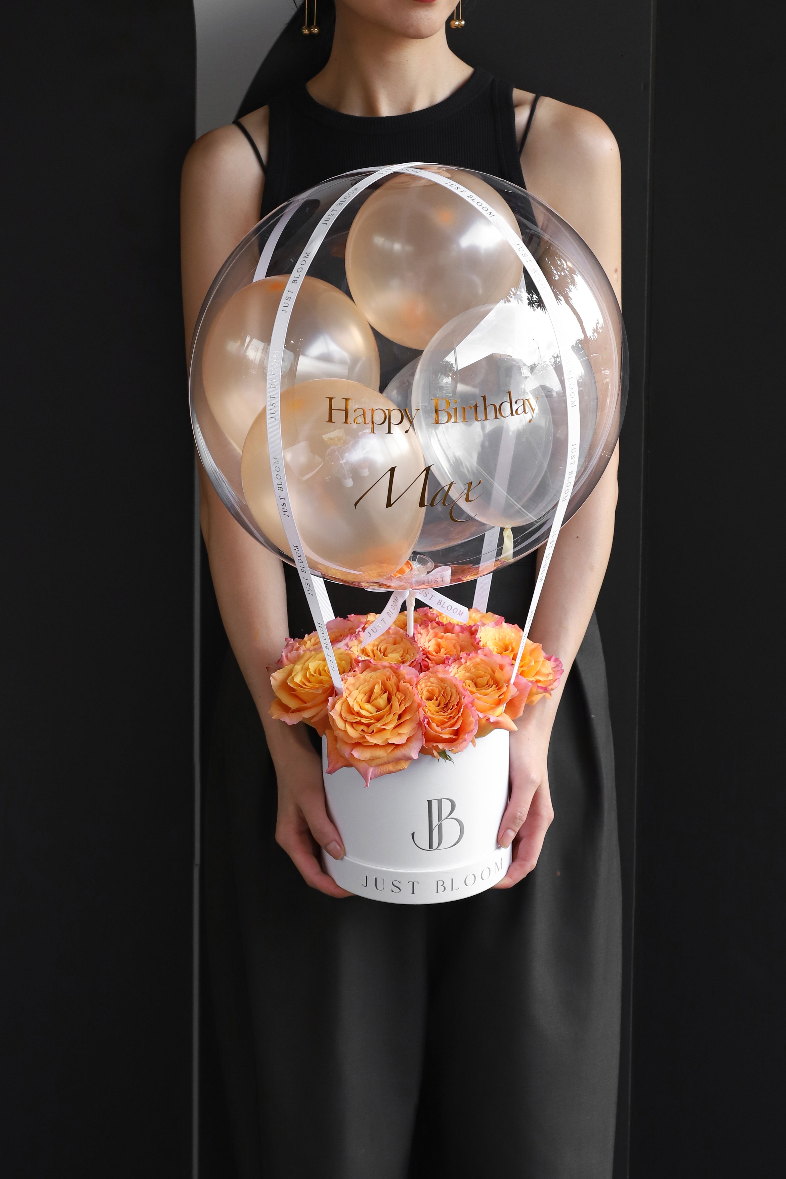 All-orange and peach rose balloon flower box with a large crystal balloon containing champagne and clear balloons in a white Just Bloom round box against a dark background — Just Bloom Hong Kong