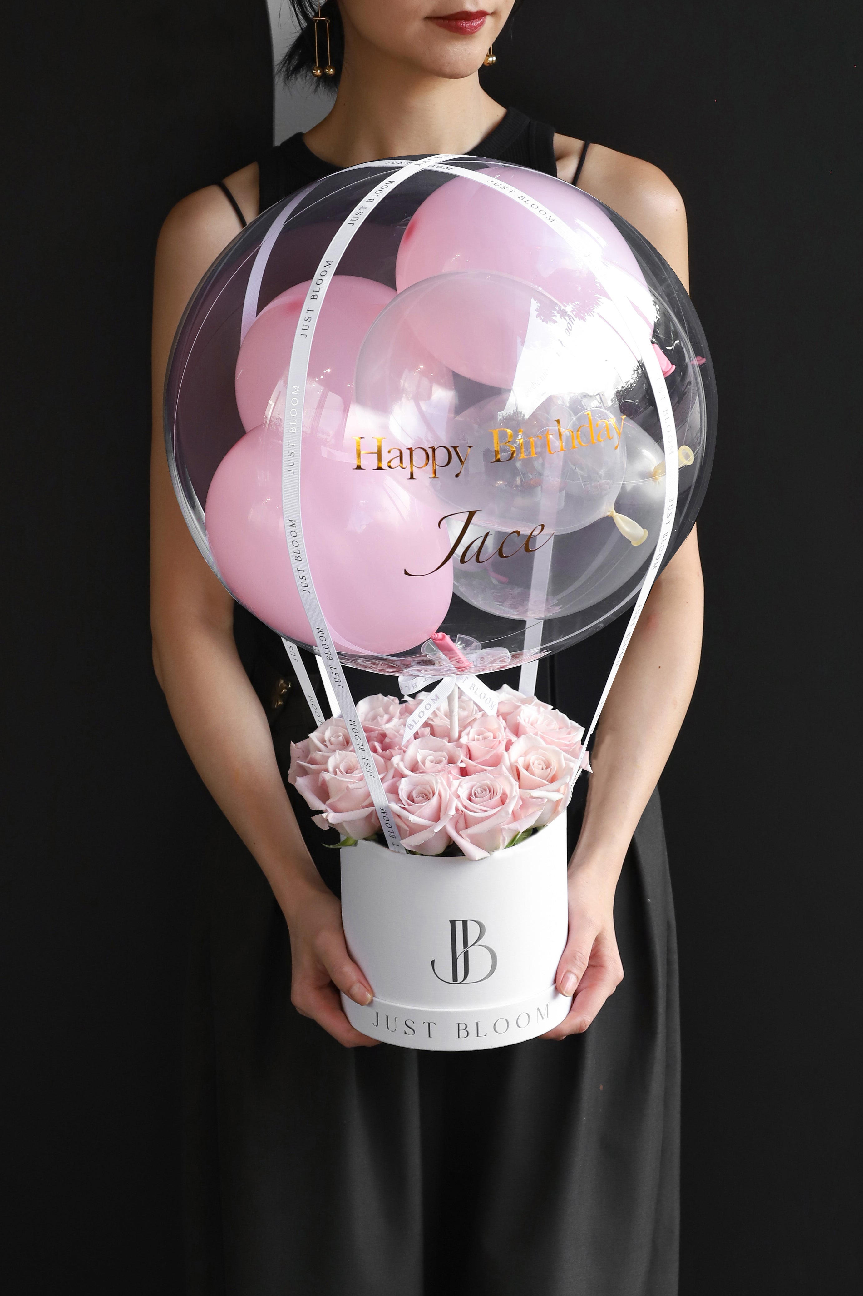 Model holding an all-soft pink rose flower box in a white Just Bloom round box against a dark background — Just Bloom Hong Kong
