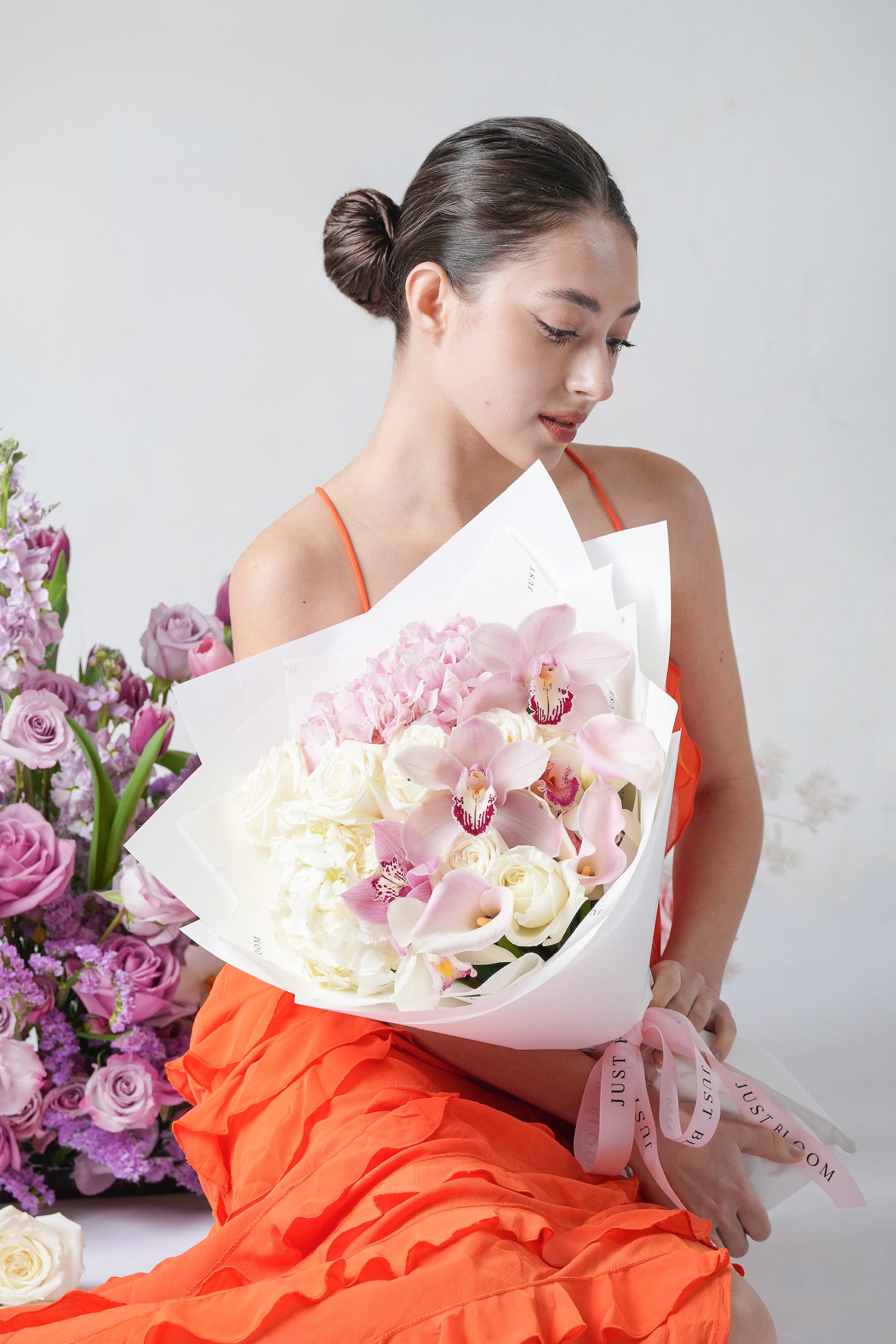 A minimal white bouquet with cymbidium orchids, white roses, calla lilies, and hydrangeas.